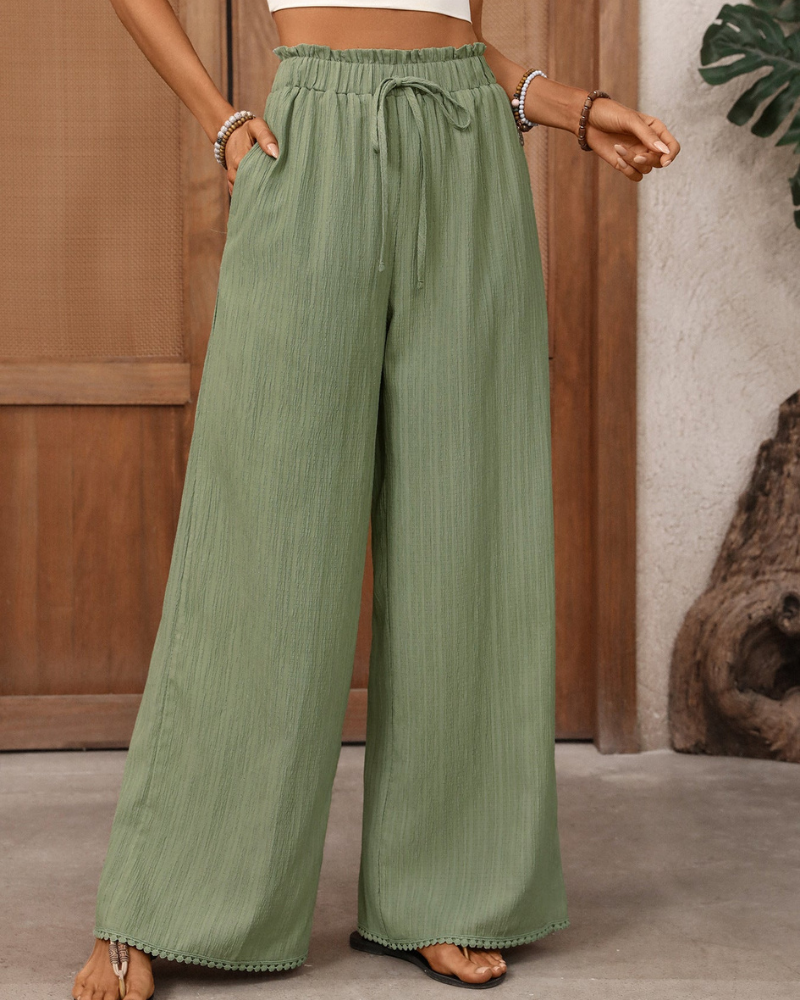 model wearing green wide leg trousers high waisted drawstring waist side view