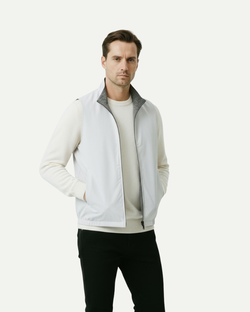 Male model wearing a light gray reversible zip-up vest styled over a sweater