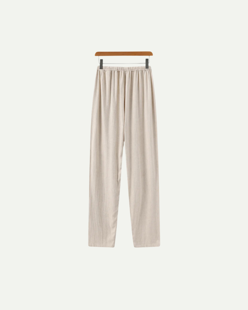 Beige linen pants on a hanger against a white background