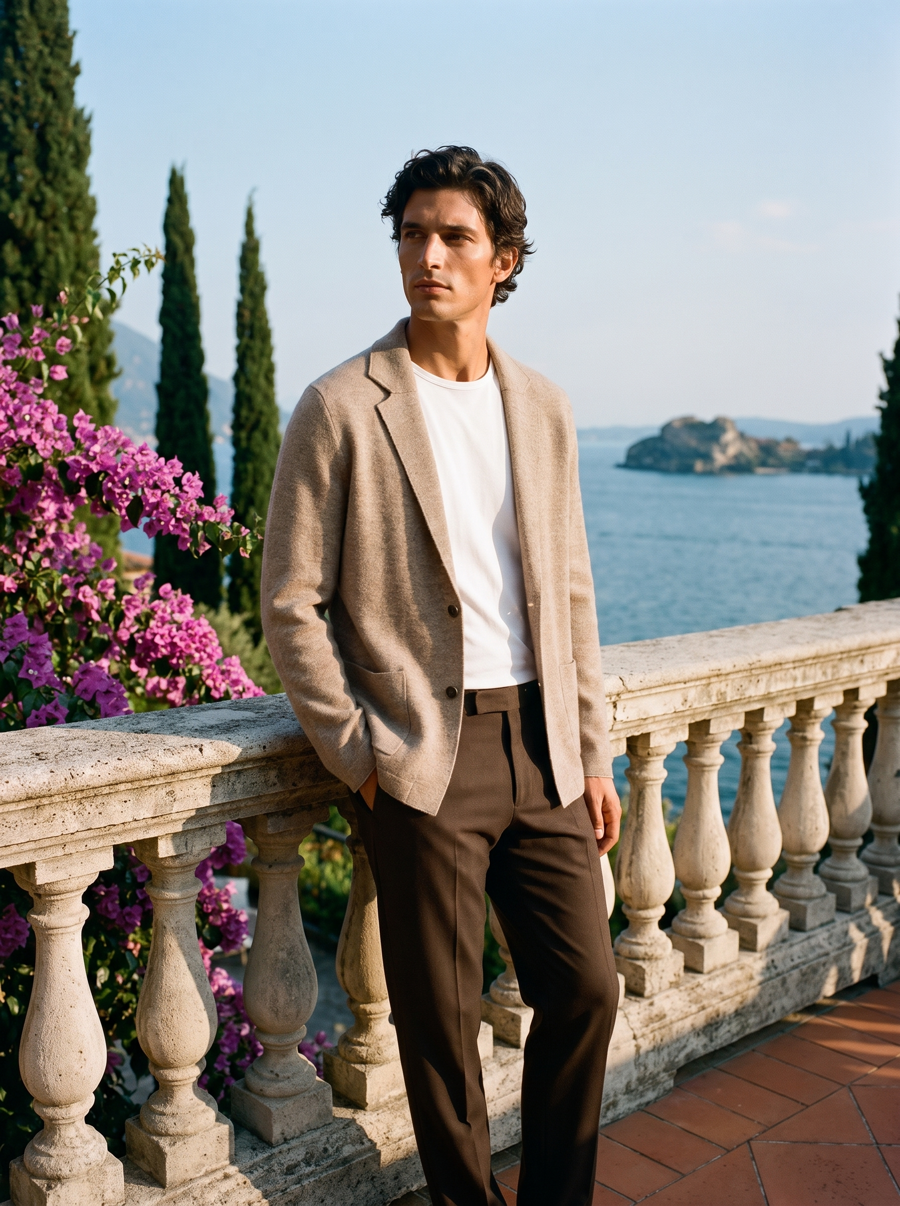 Full body view of a man in a beige wool blazer cardigan and brown trousers on a Lake Como terrace — Aveloire