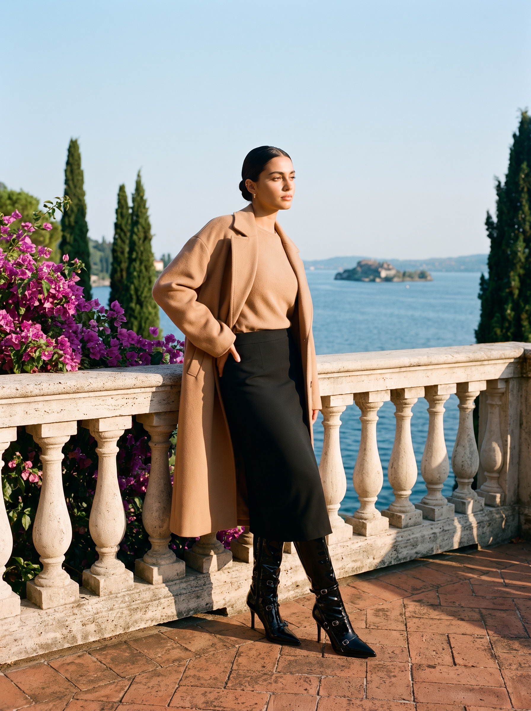 Full body front view of a woman in black patent stiletto knee high boots on a Lake Como terrace — Aveloire