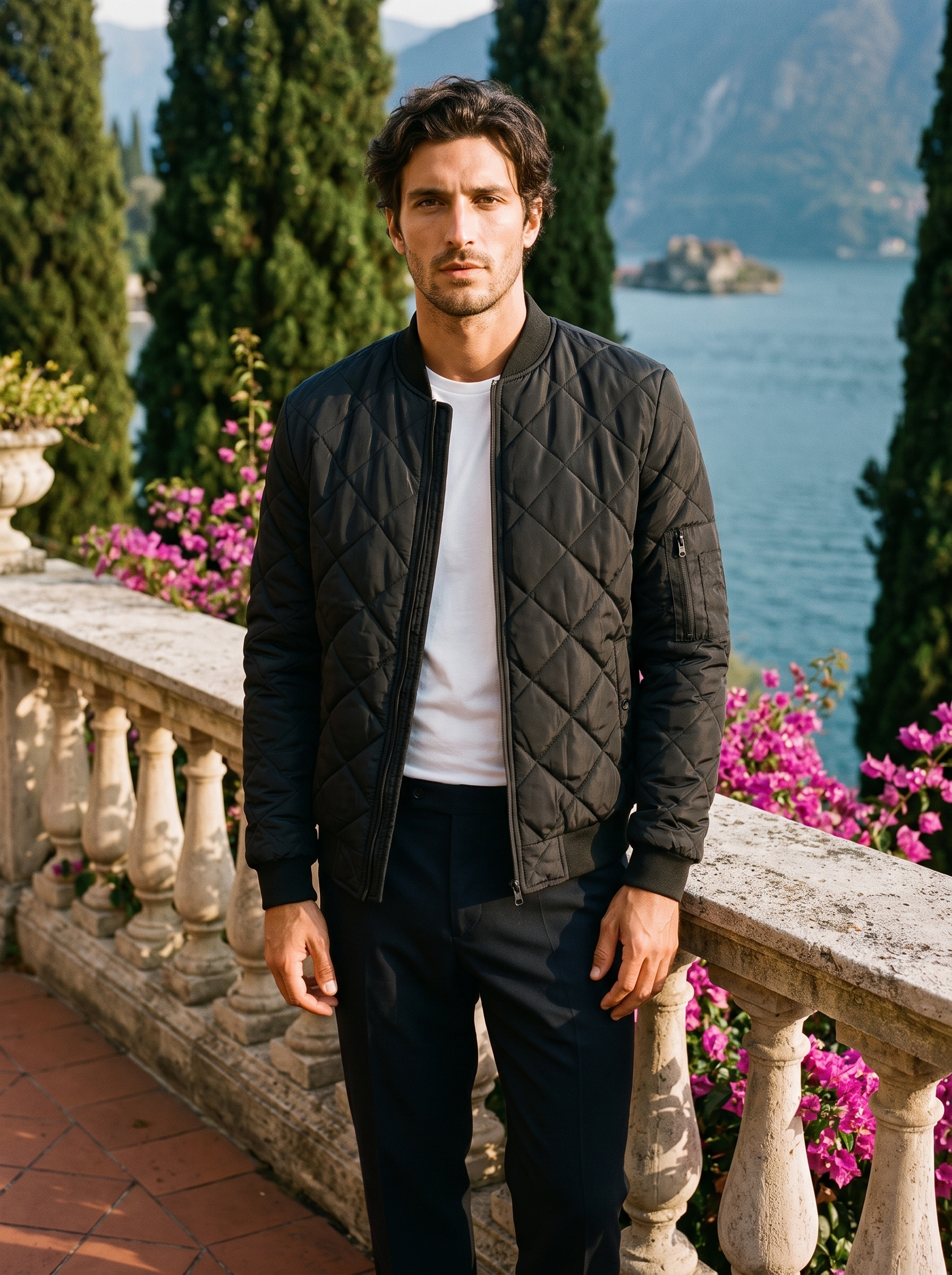 Man wearing a black quilted bomber jacket, full-length front view on a Lake Como terrace, old money style — Aveloire