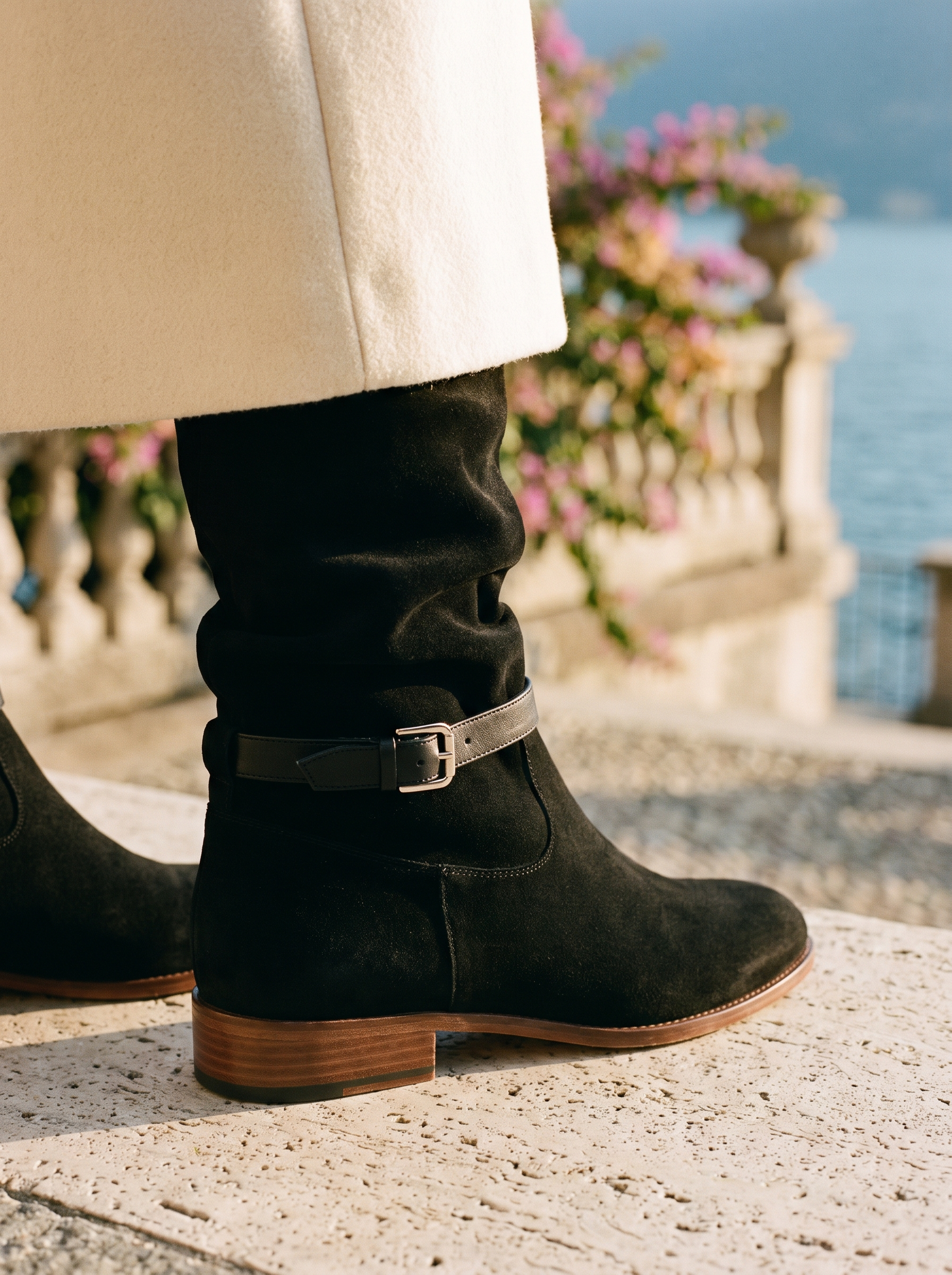 Detail of buckled ankle strap on black suede-look knee high boot