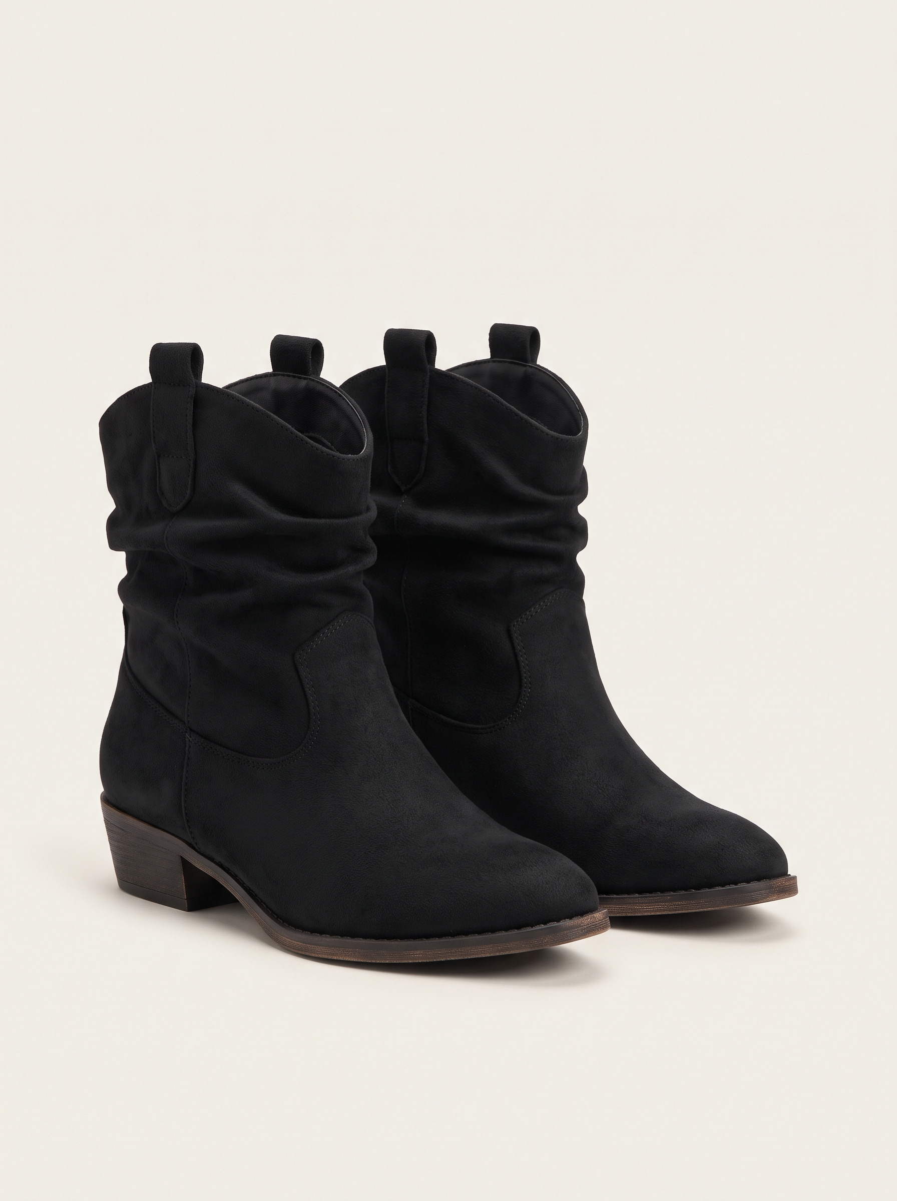 Pair of black suede-look slouch western ankle boots on off-white background