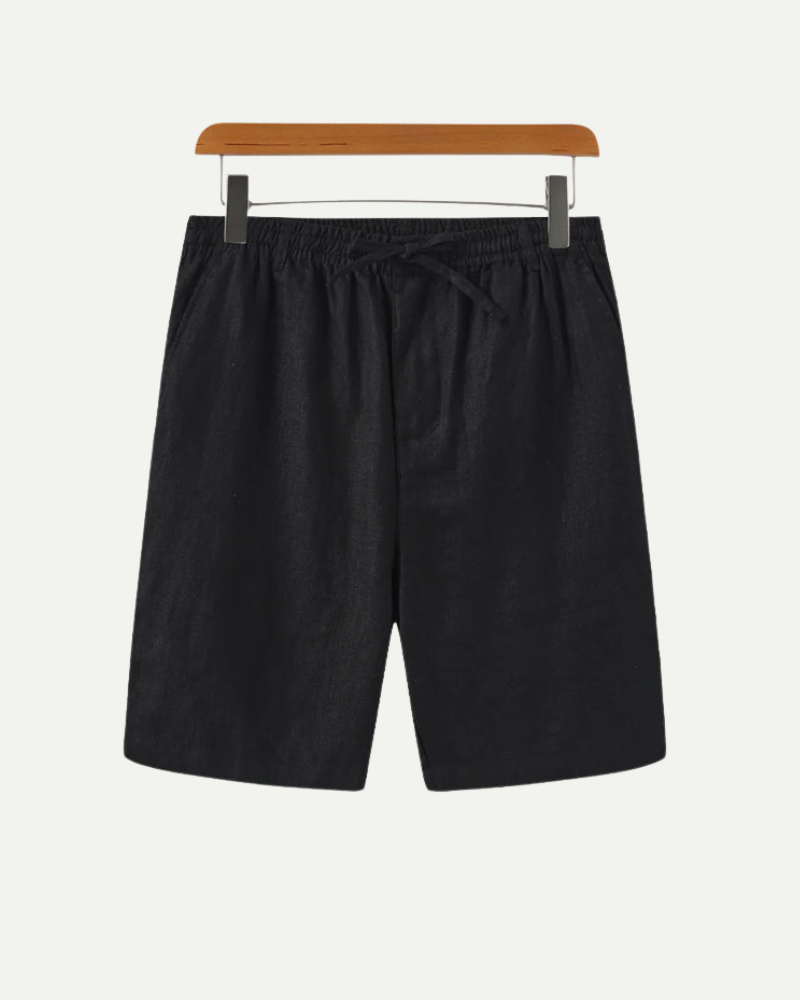Black linen shorts on a hanger against a white background