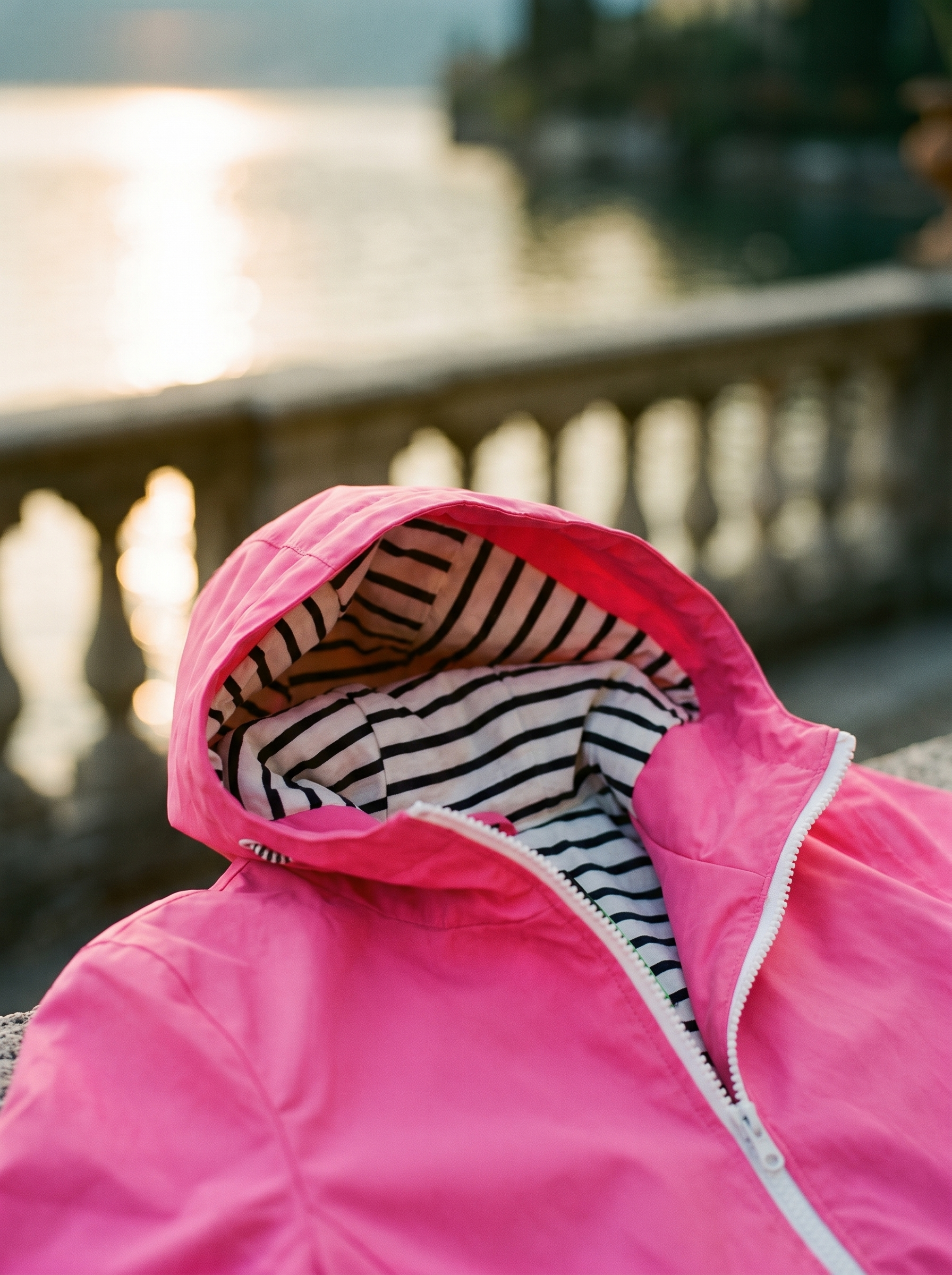 Bright pink hooded waterproof rain jacket, hood and striped lining detail — Aveloire