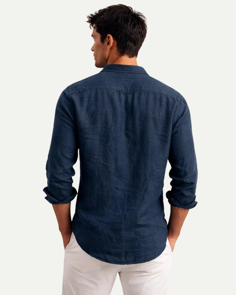 Man wearing a navy blue shirt and white pants on a white background
