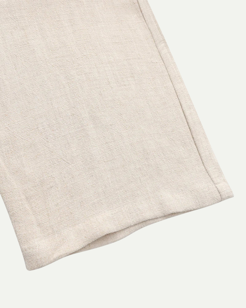 Beige linen fabric folded on a white background