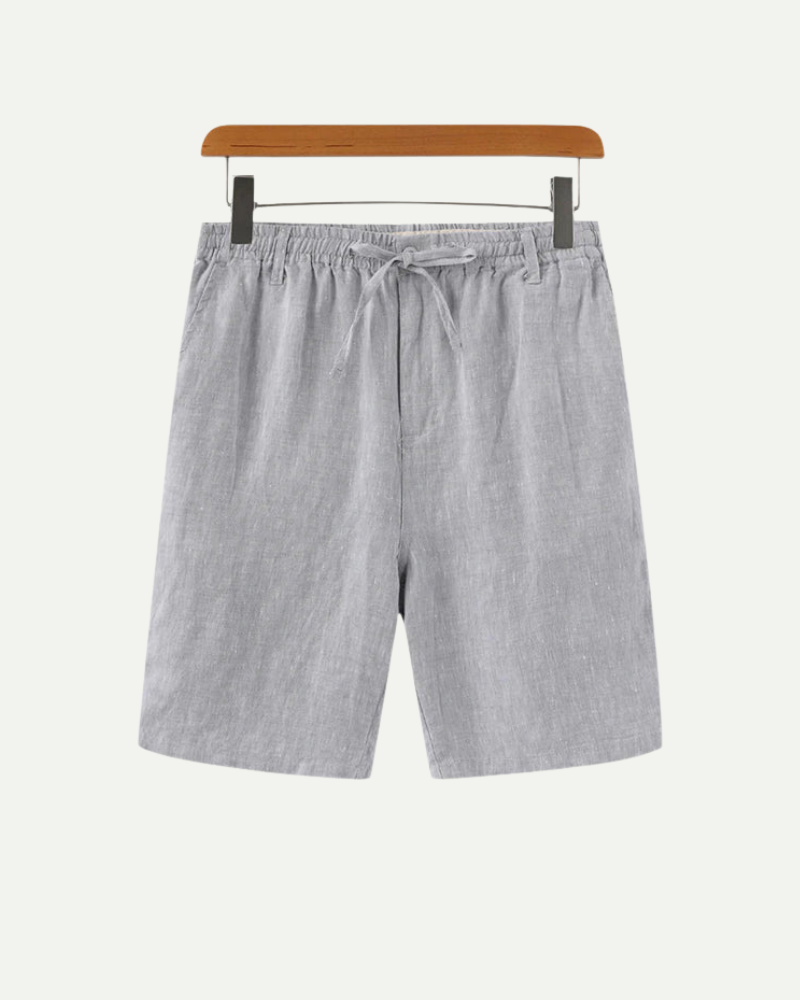 Gray linen shorts on a hanger against a white background