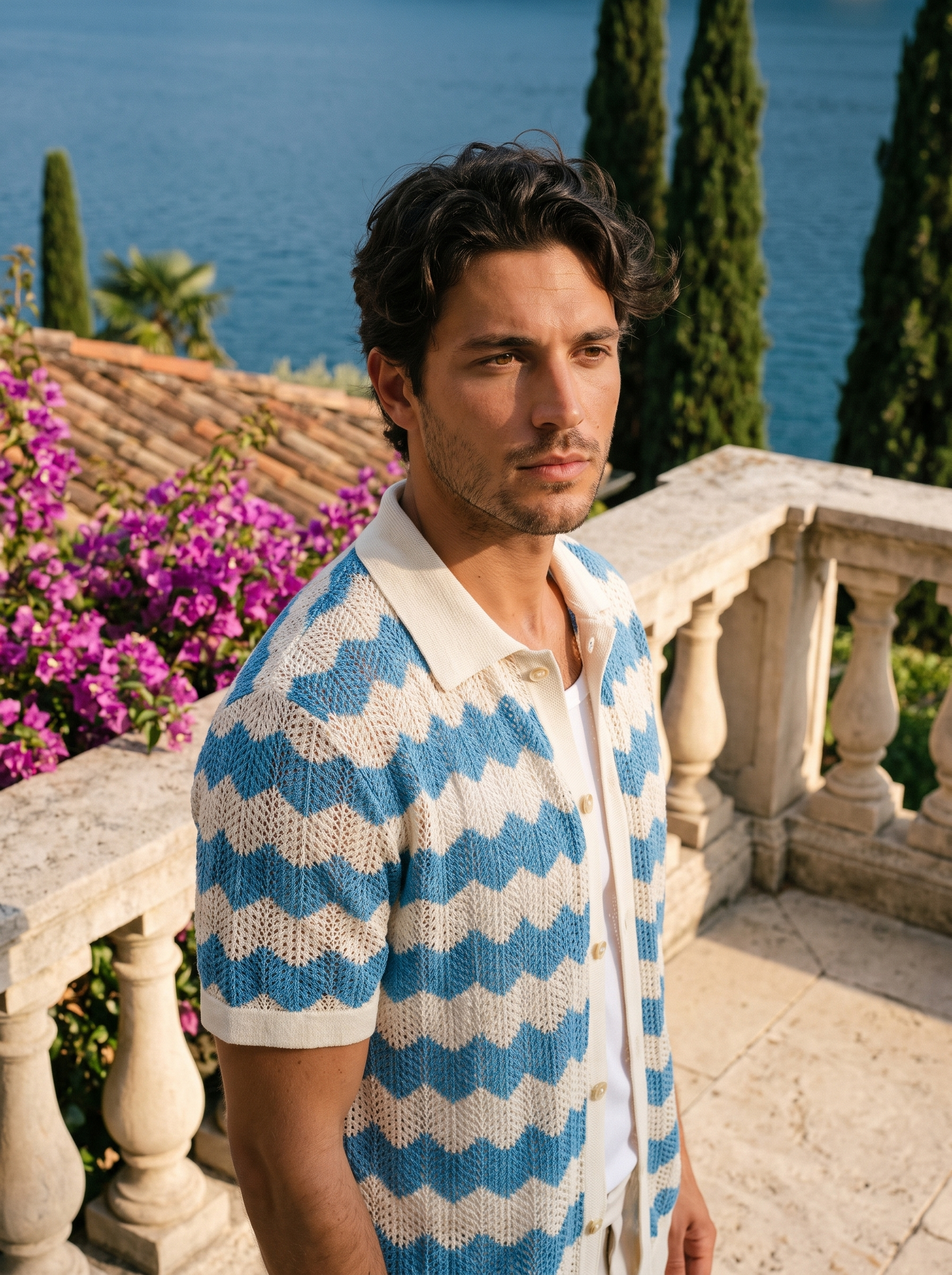 Man wearing a blue and cream wave knit button shirt on a balcony overlooking Lake Como, old money style — Aveloire