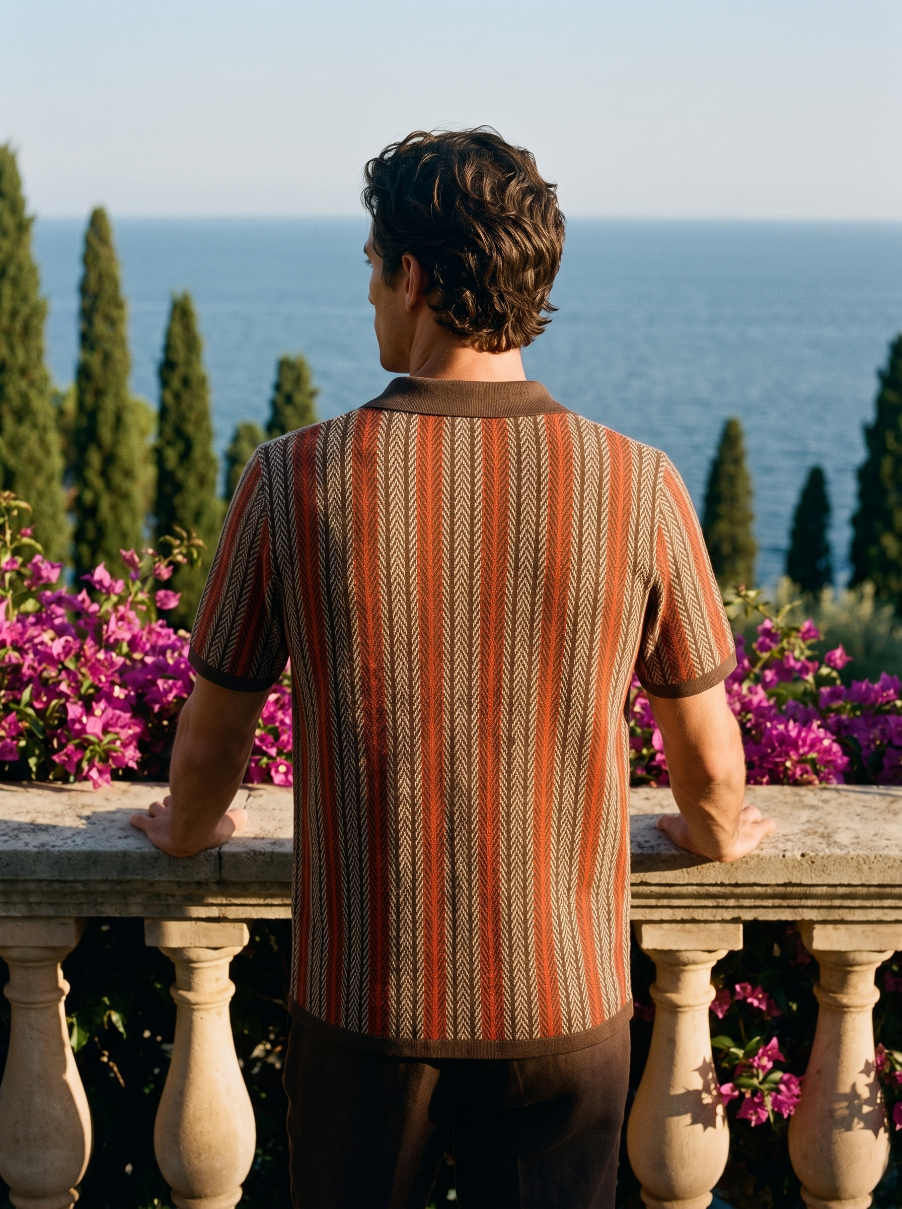Back view of a man in a brown striped knit button polo overlooking Lake Como — Aveloire