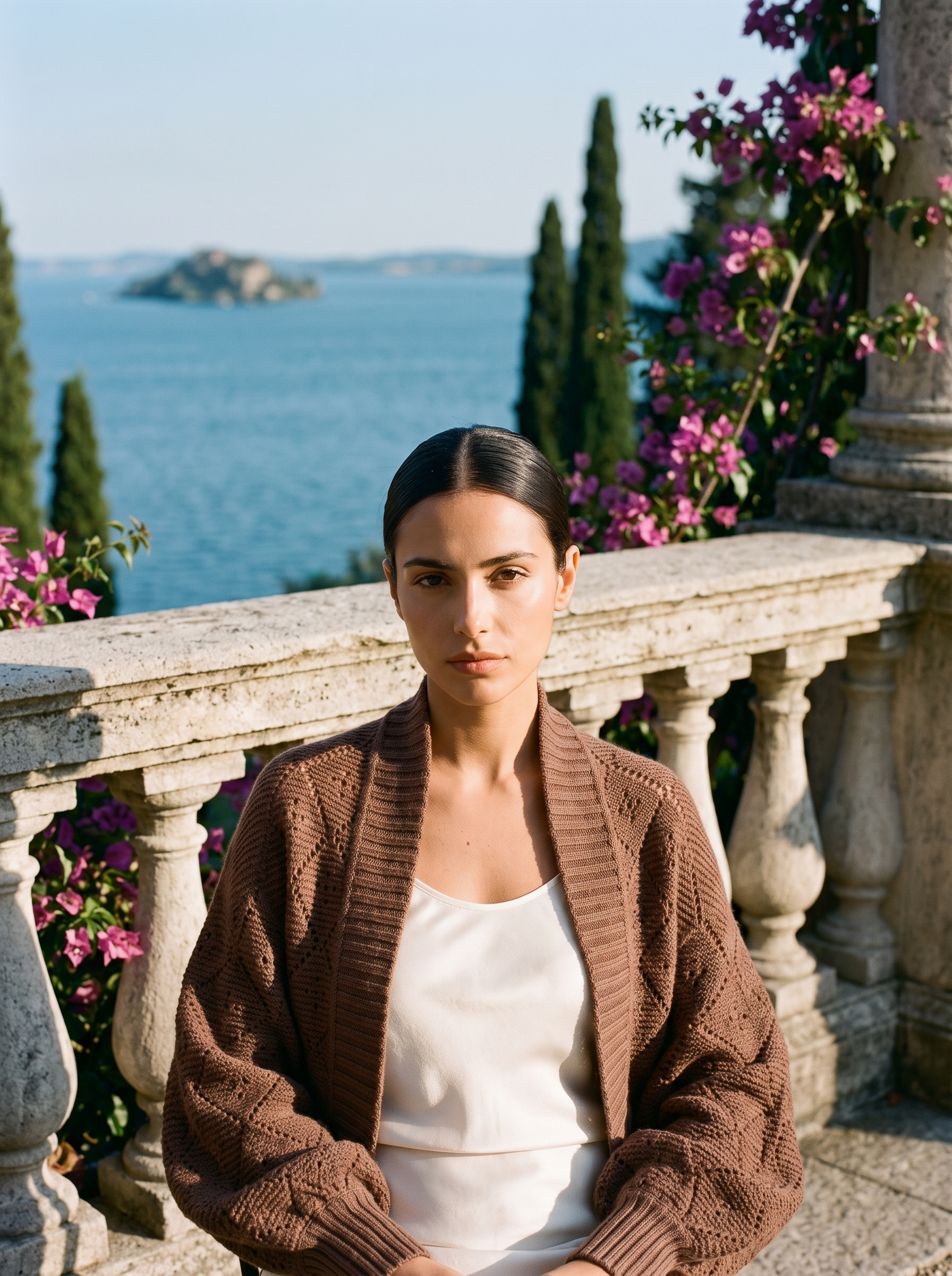 Woman wearing a cocoa brown cropped open-front knit shrug cardigan on a Lake Como terrace — Aveloire
