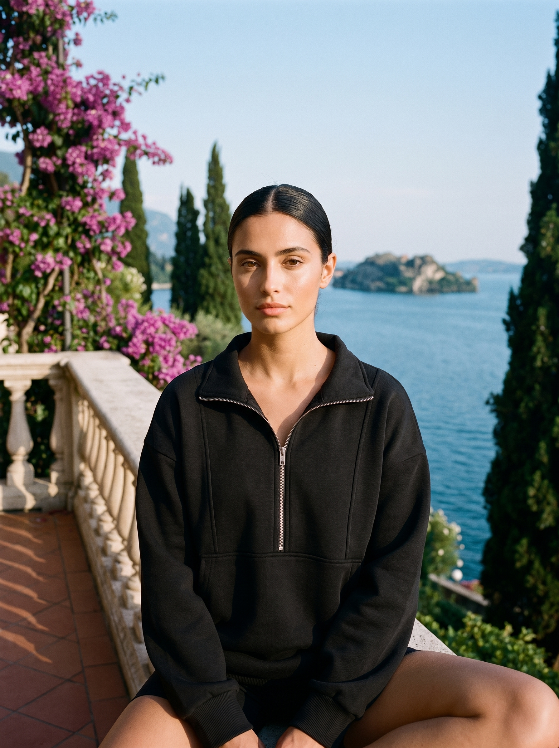 Woman wearing a black oversized half-zip pocket sweatshirt on a Lake Como terrace — Aveloire