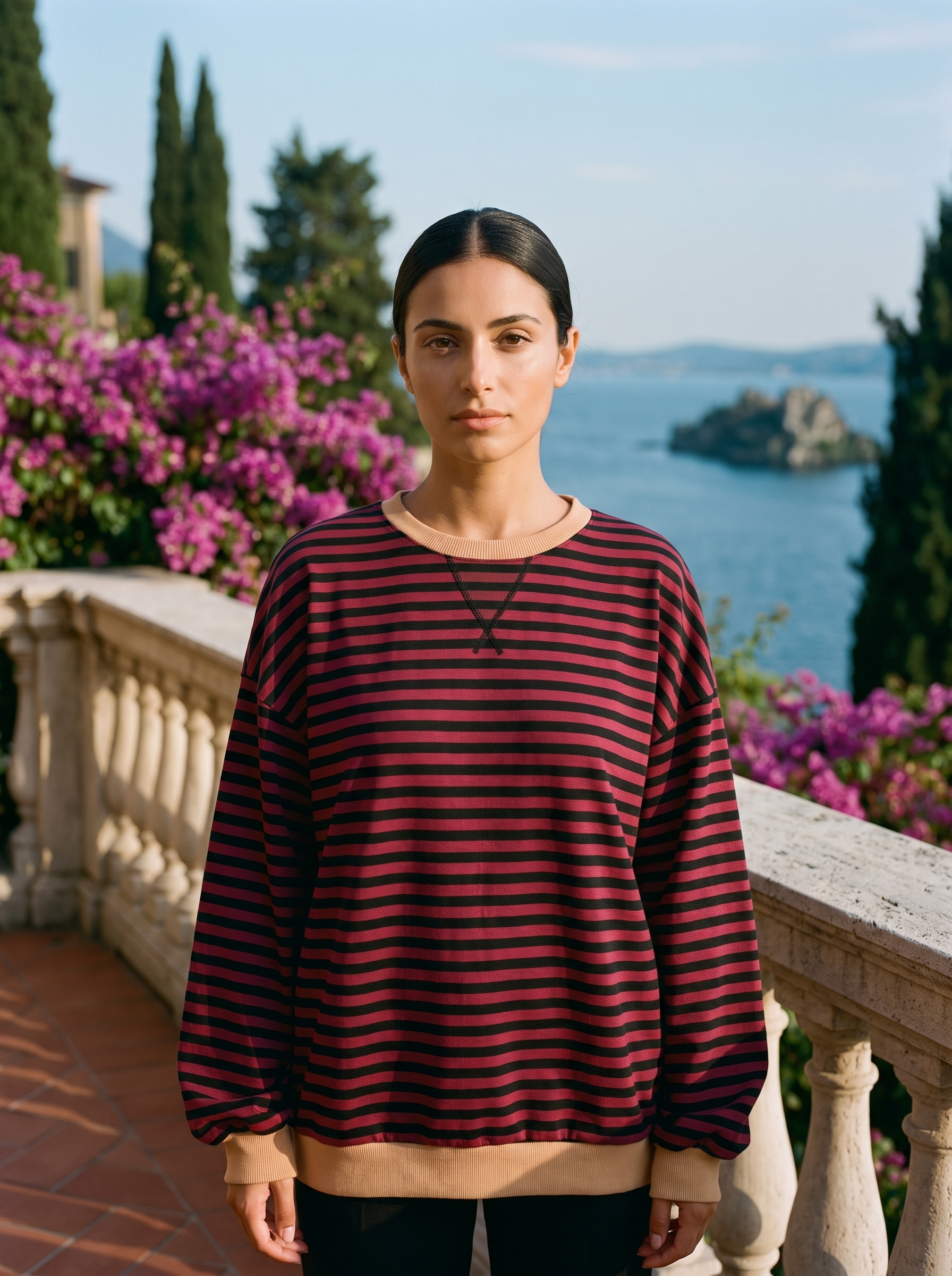 Woman wearing a wine and black striped oversized sweatshirt on a Lake Como terrace — Aveloire