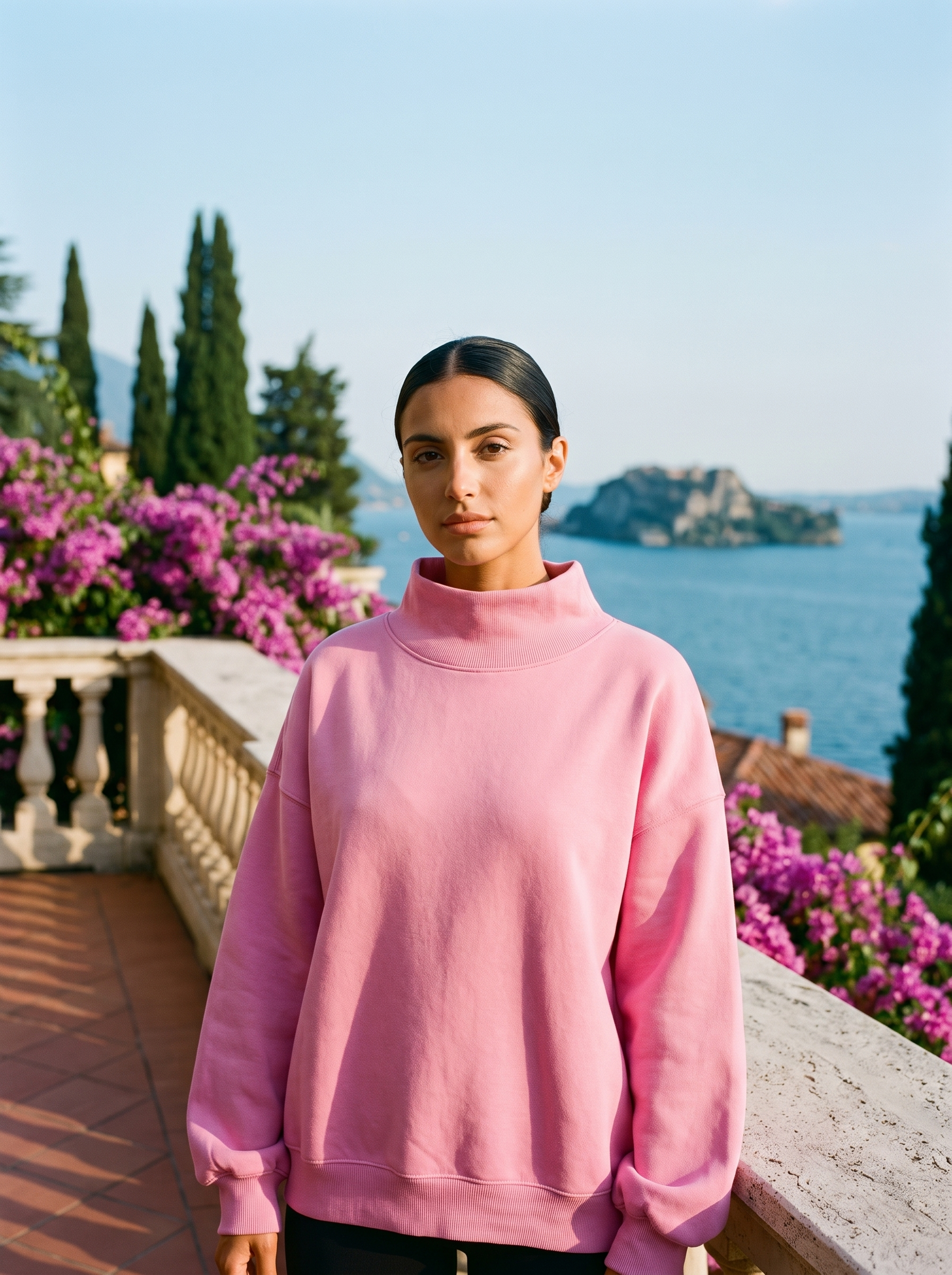 Woman wearing a rose pink oversized turtleneck sweatshirt on a Lake Como terrace — Aveloire
