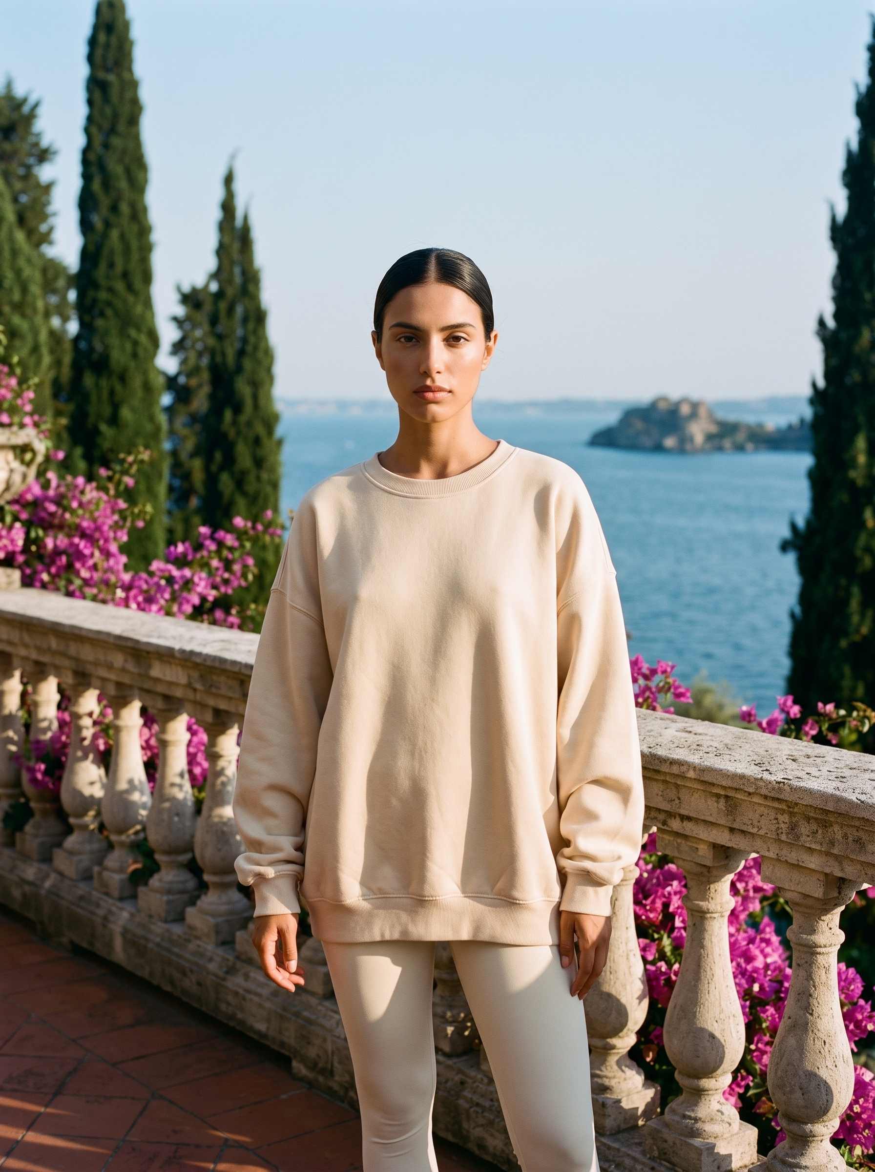 Woman wearing a cream beige oversized crew neck sweatshirt full length on a Lake Como terrace, old money style — Aveloire