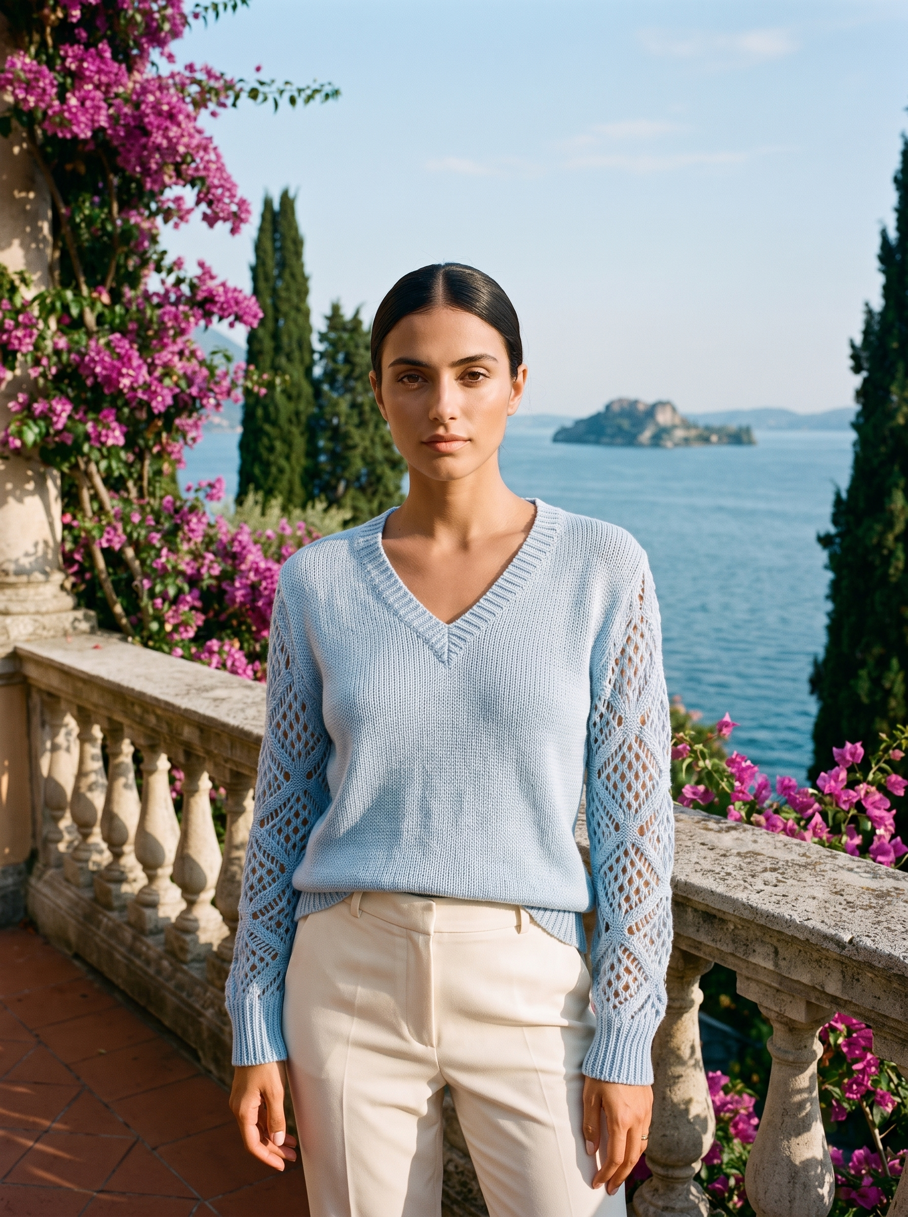 Woman wearing a sky blue V-neck knit jumper on a Lake Como terrace, old money style — Aveloire