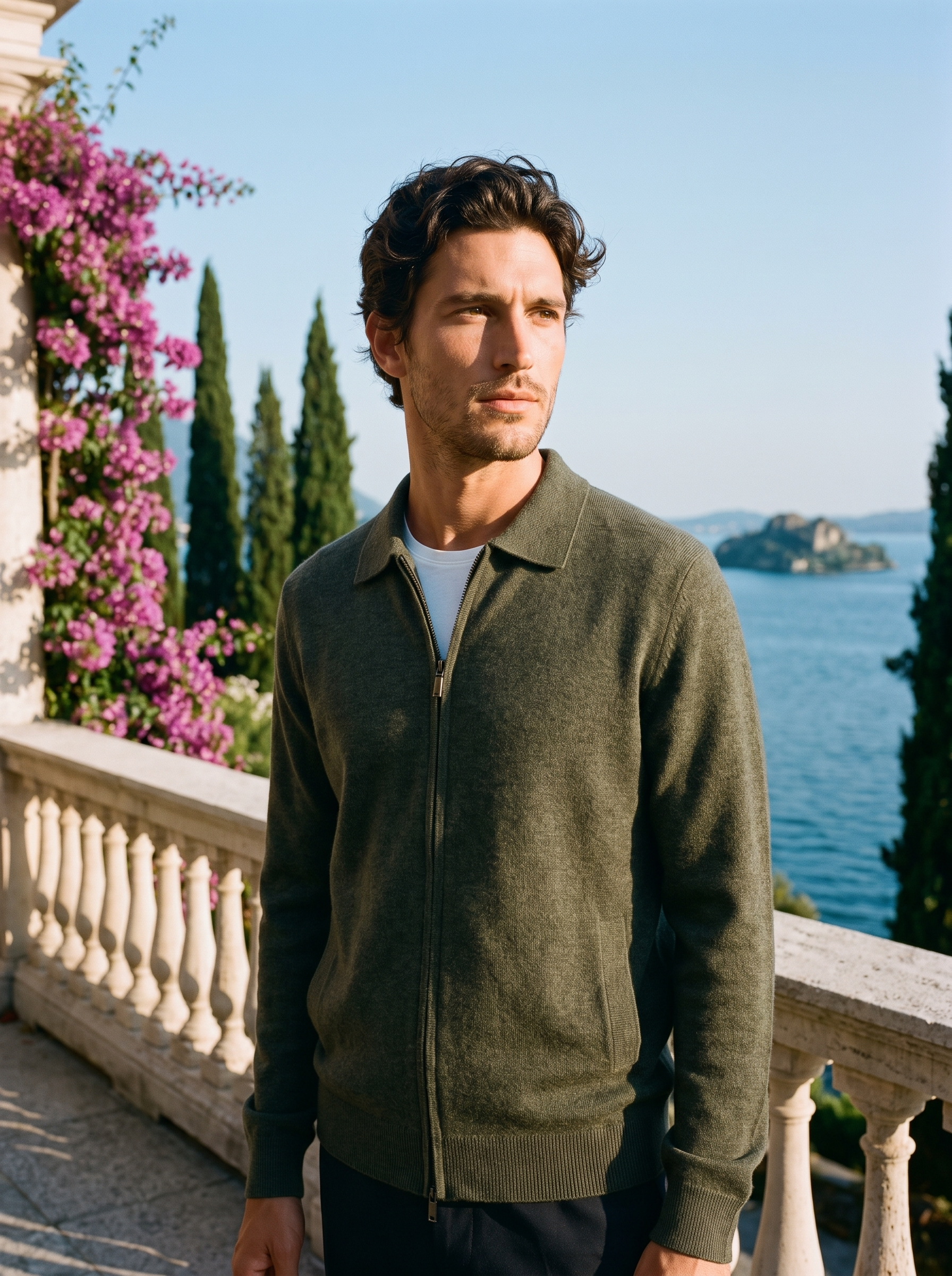 Man wearing an army green mercerized wool zip-up collared cardigan on a terrace overlooking Lake Como, old money style — Aveloire