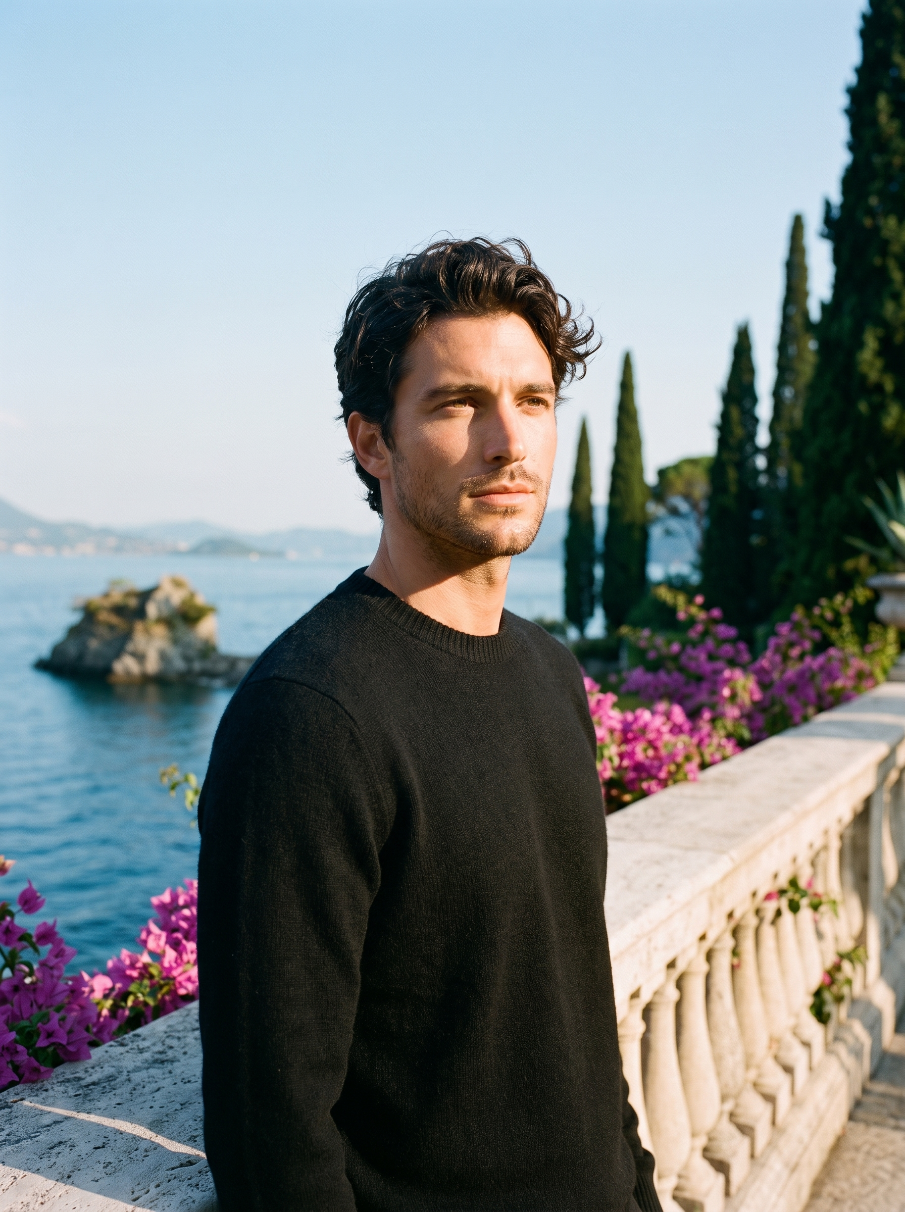 Man wearing a black classic crewneck sweater on a terrace overlooking Lake Como, old money style — Aveloire