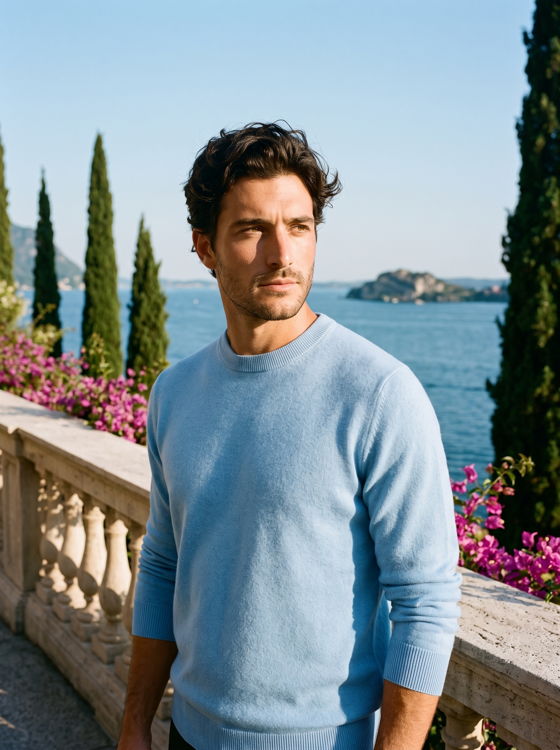 Man wearing a light blue 100% wool crewneck sweater on a terrace overlooking Lake Como, old money style — Aveloire