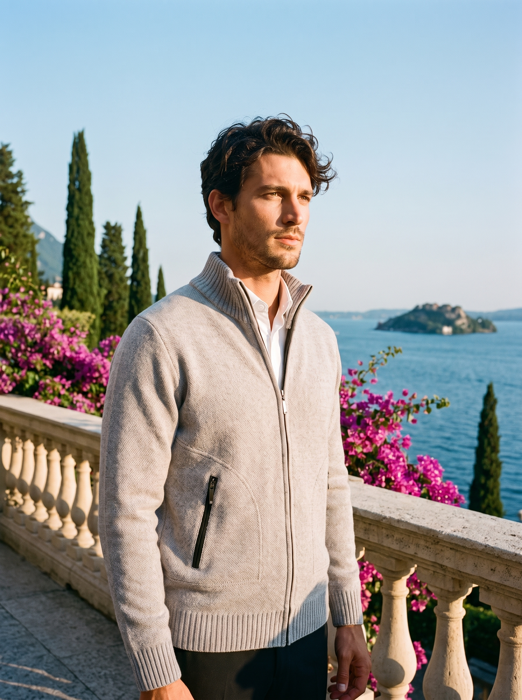 Man wearing a light gray melange zip-up stand collar cardigan on a terrace overlooking Lake Como, old money style — Aveloire