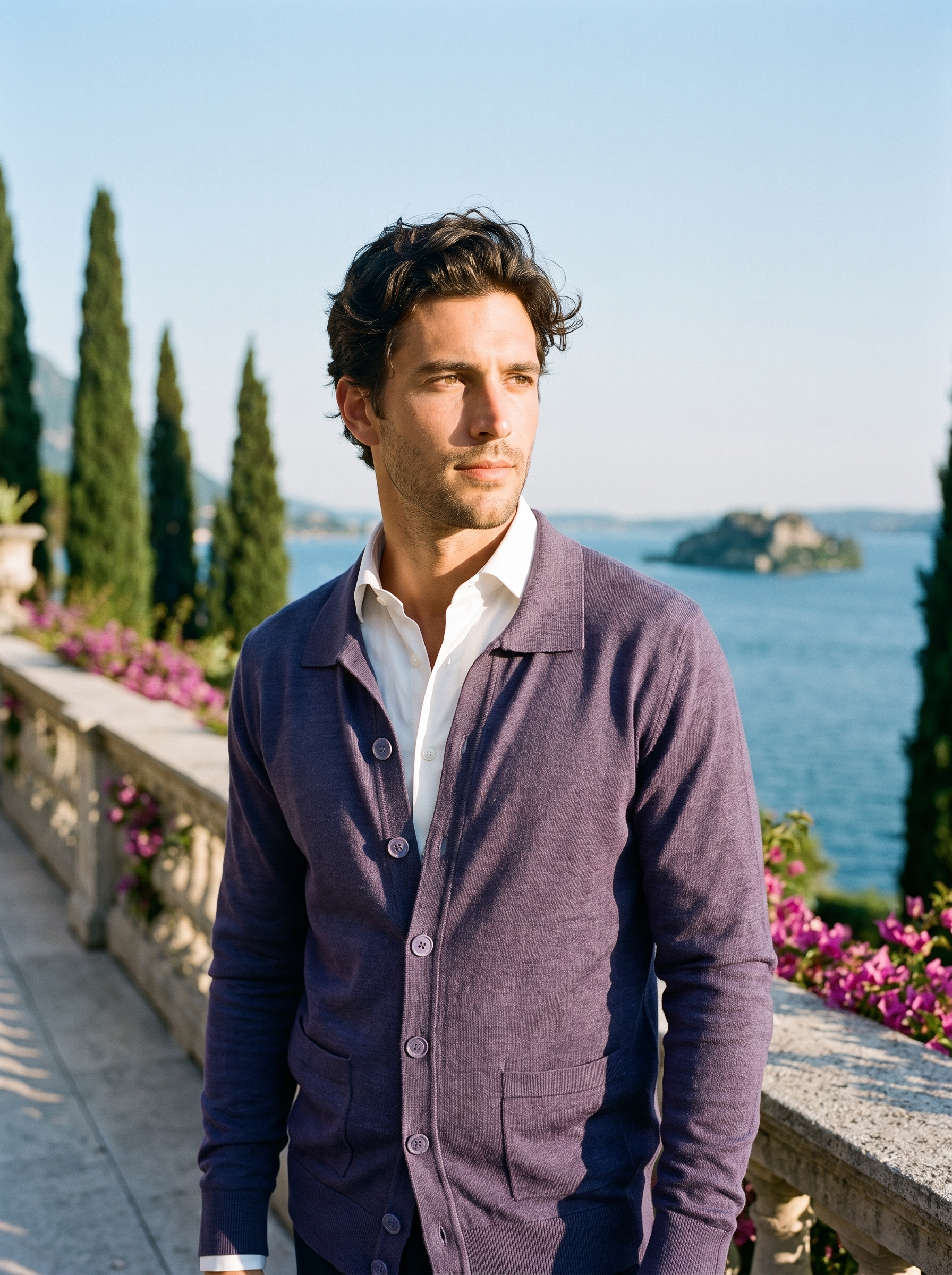 Man wearing a purple button-up collared cardigan on a terrace overlooking Lake Como, old money style — Aveloire