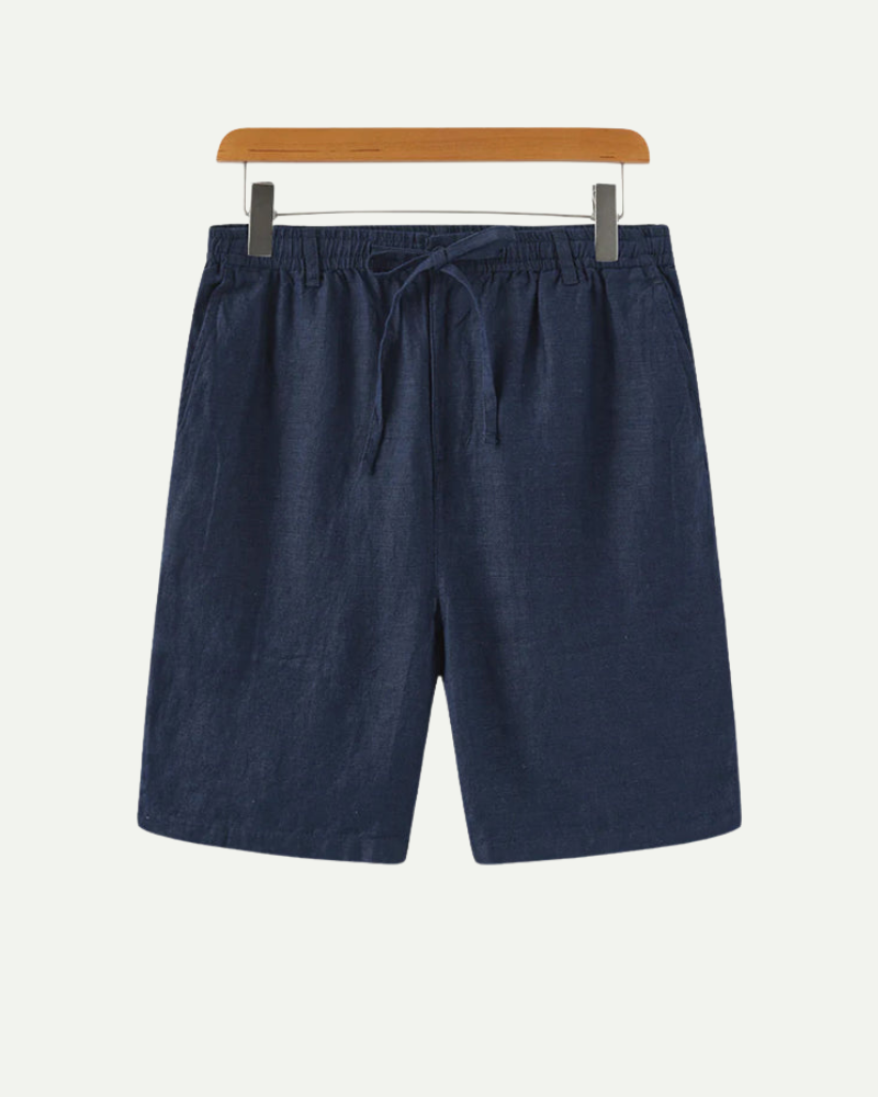 Navy linen blue shorts on a hanger against a white background