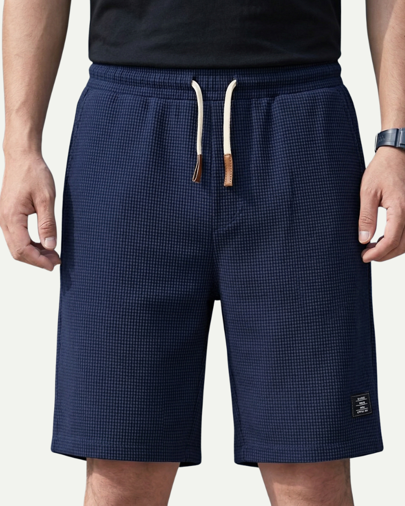 Navy waffle shorts with a drawstring on a plain background