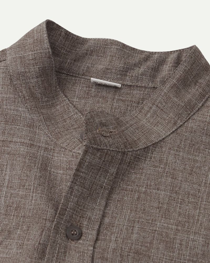 Close-up of a brown shirt collar with buttons on a white background