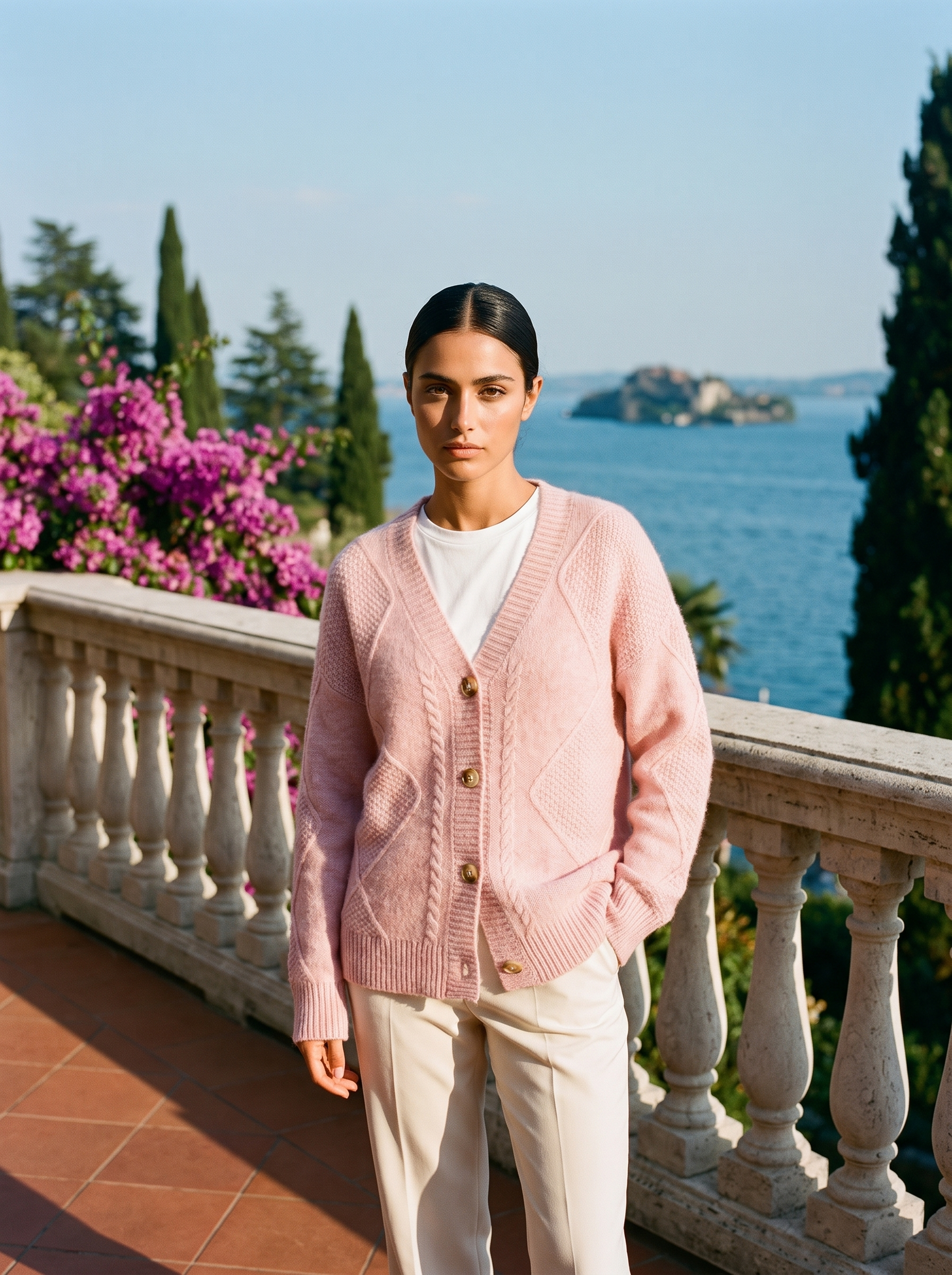 Pink cable-knit cardigan, full body front view on a Lake Como terrace — Aveloire