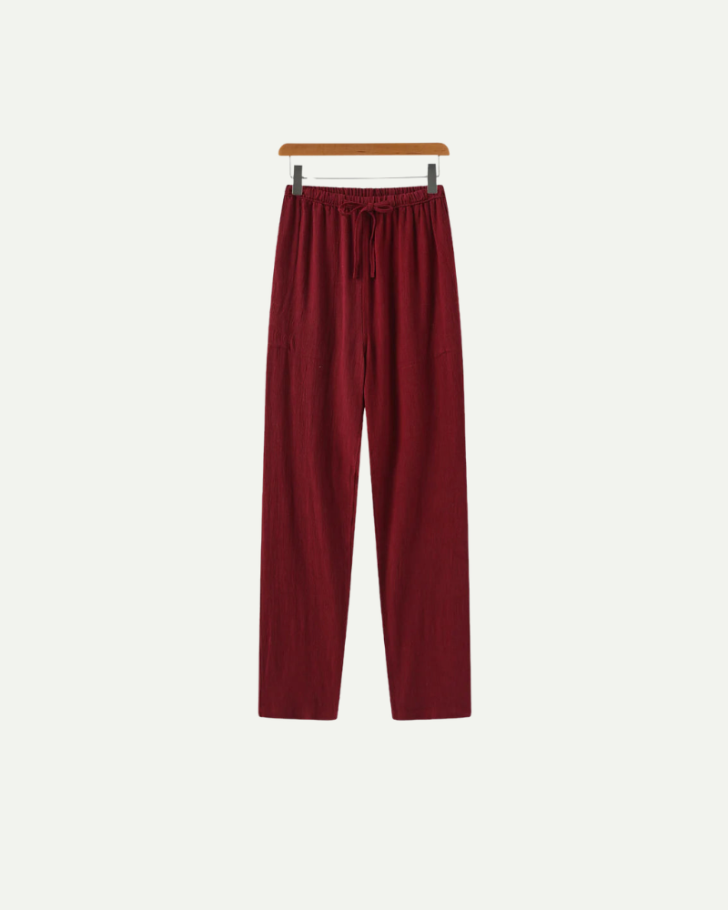 linen red pants on a hanger against a white background
