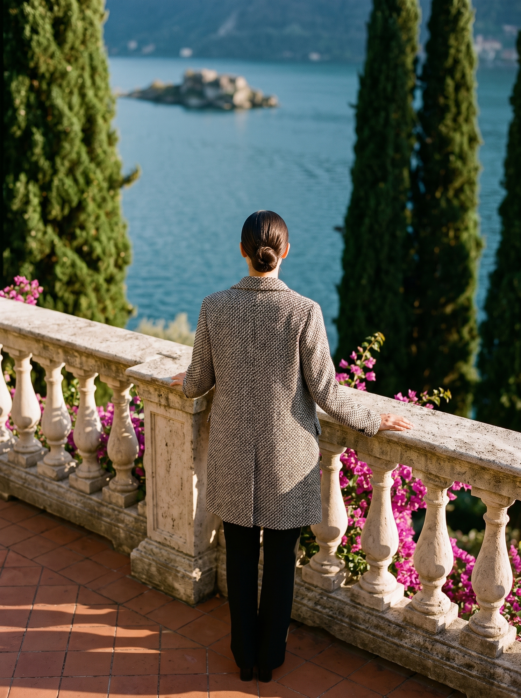 Back view of a black-and-white tweed wool coat on a Lake Como terrace — Aveloire