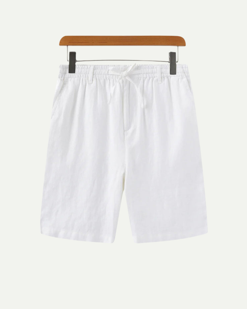 White linen shorts on a wooden hanger against a white background