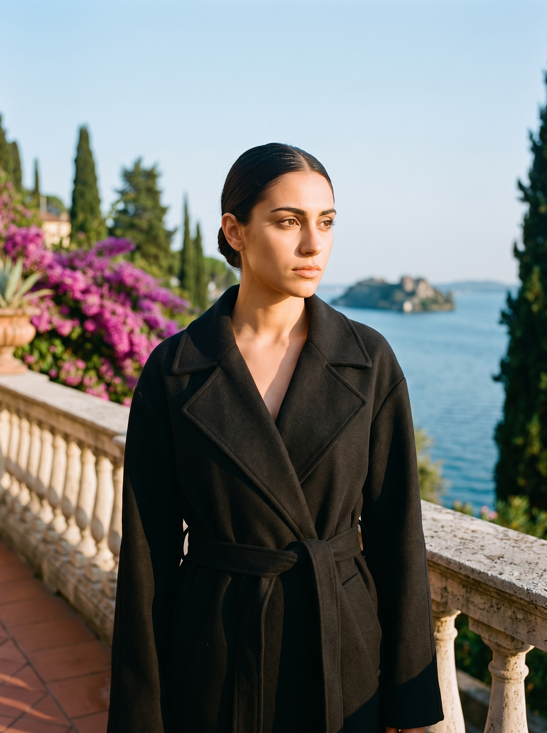 Woman wearing black longline winter trench coat on a Lake Como terrace — Aveloire