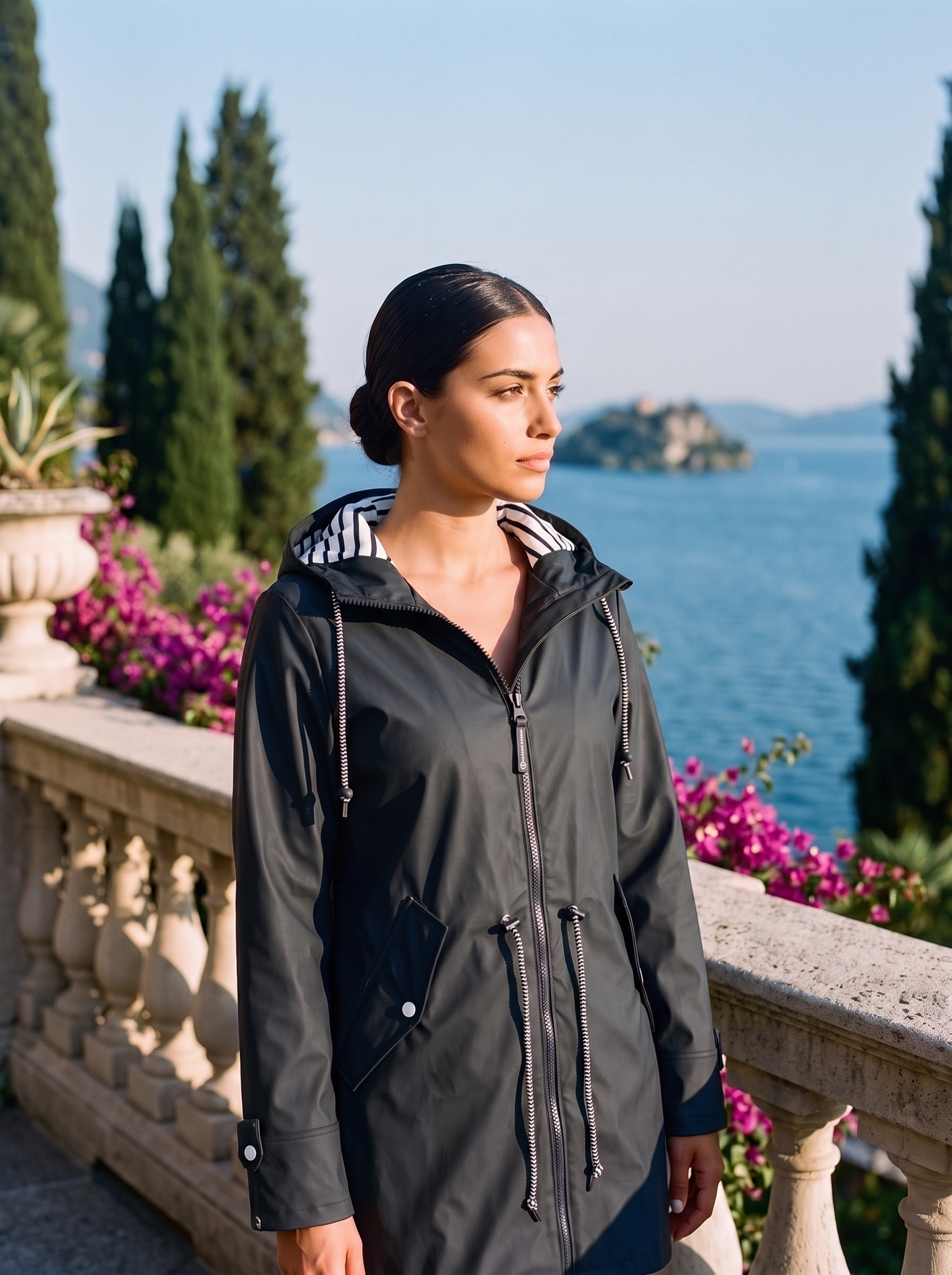 Woman wearing a black hooded waterproof rain jacket on a Lake Como terrace — Aveloire