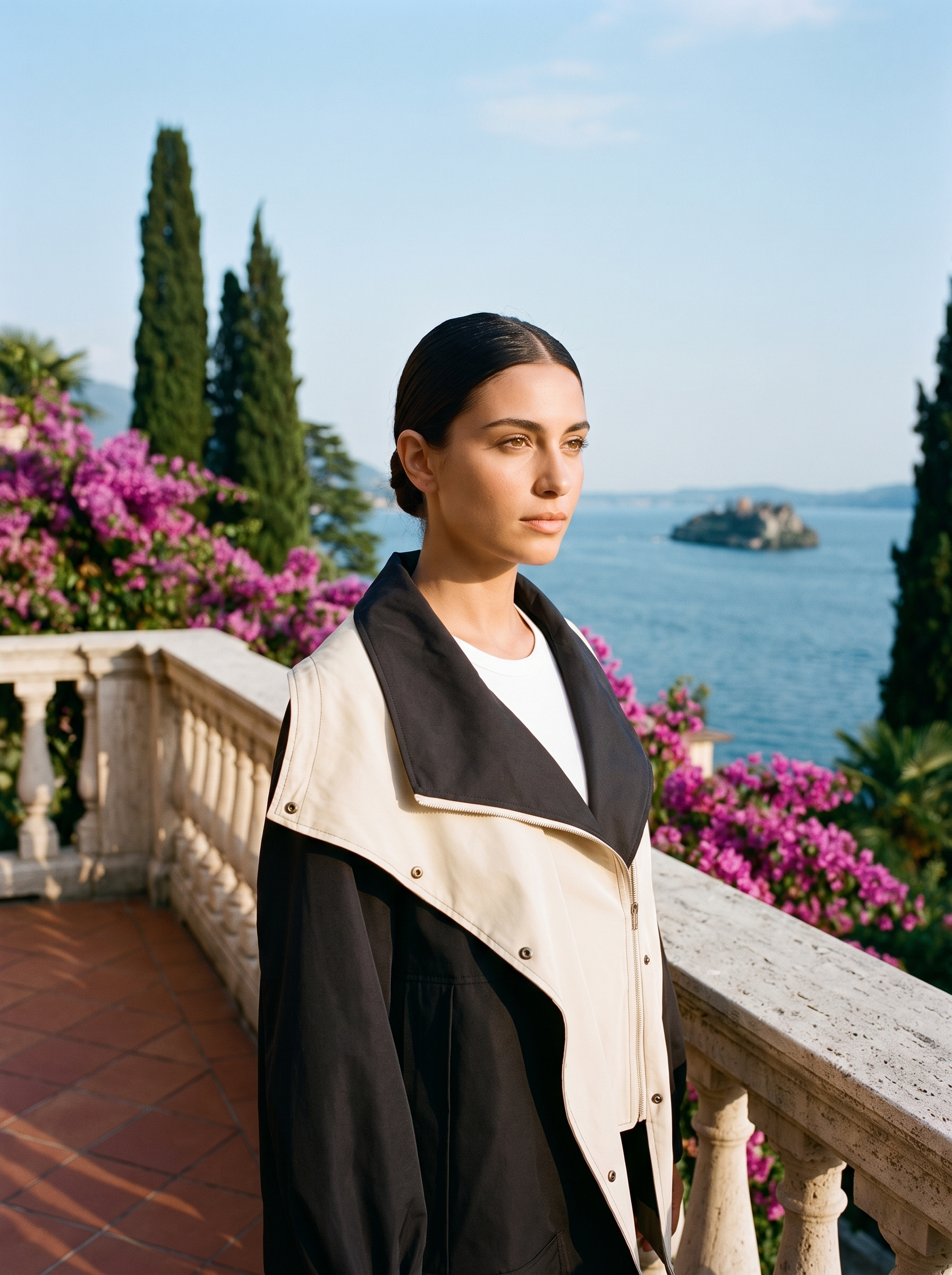 Woman wearing a black windbreaker jacket on a terrace overlooking Lake Como, old money style — Aveloire