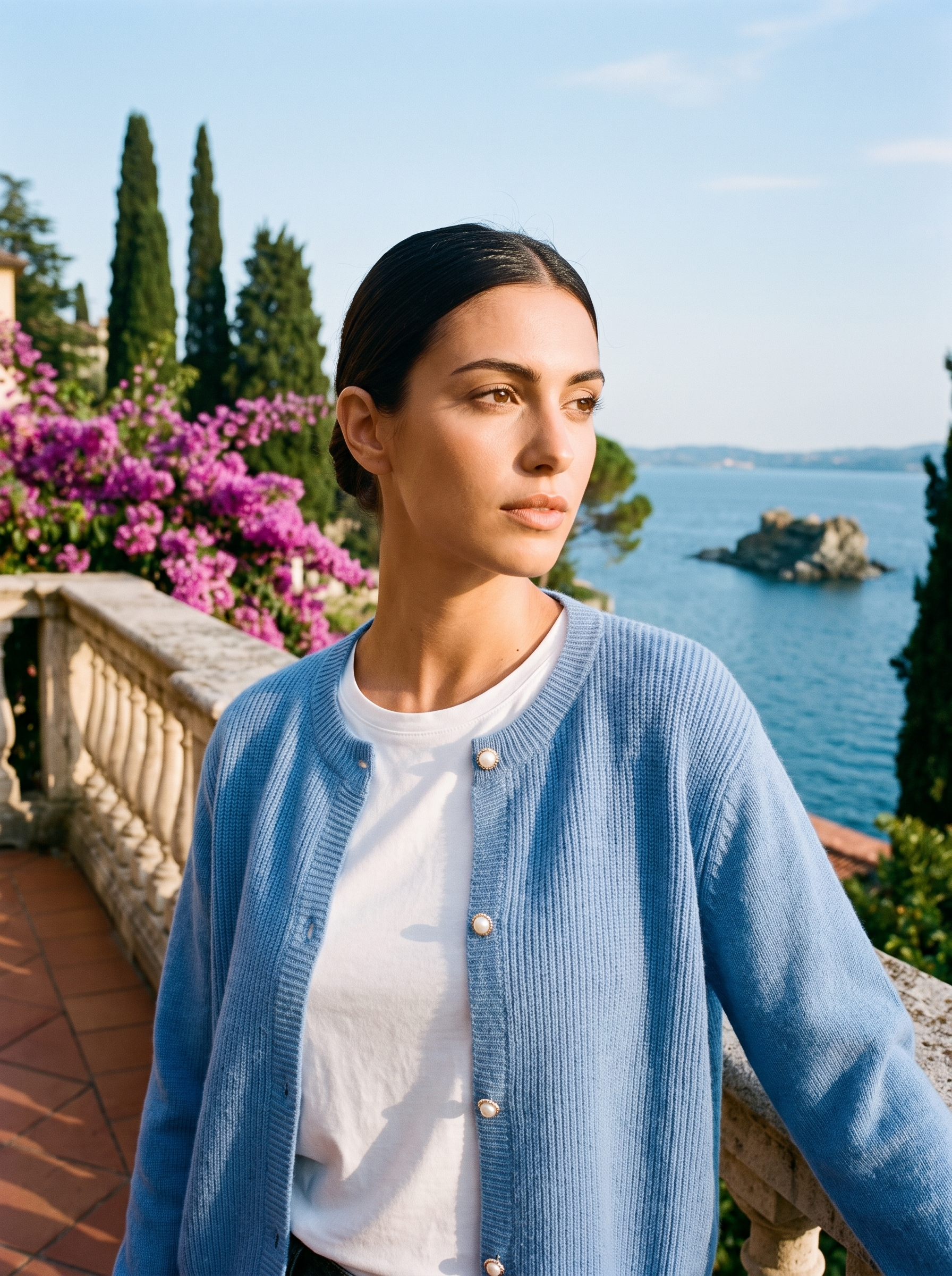 Woman wearing a blue round-neck cardigan on a terrace overlooking Lake Como, old money style — Aveloire