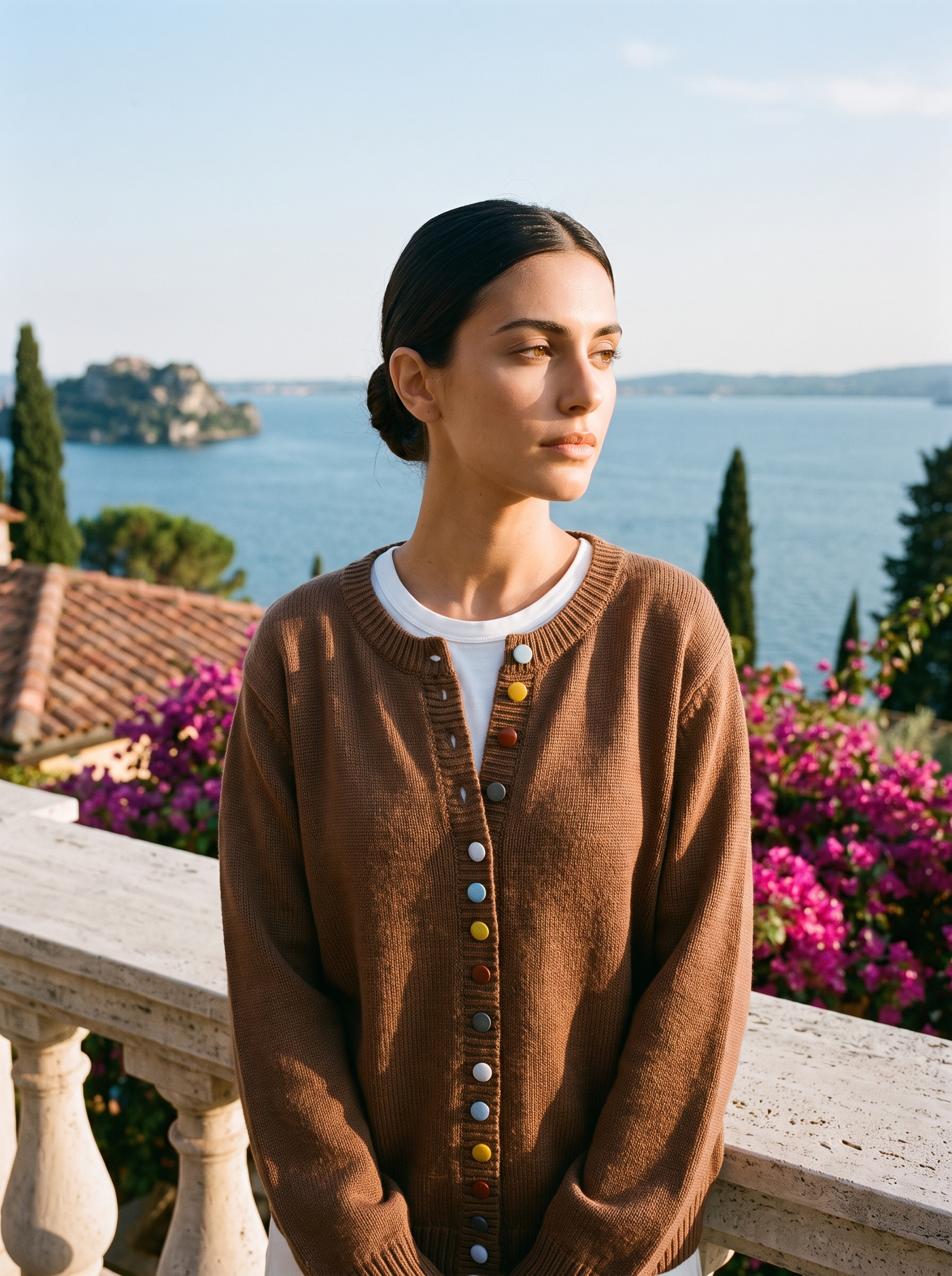 Woman wearing a brown button cardigan on a terrace overlooking Lake Como, old money style — Aveloire