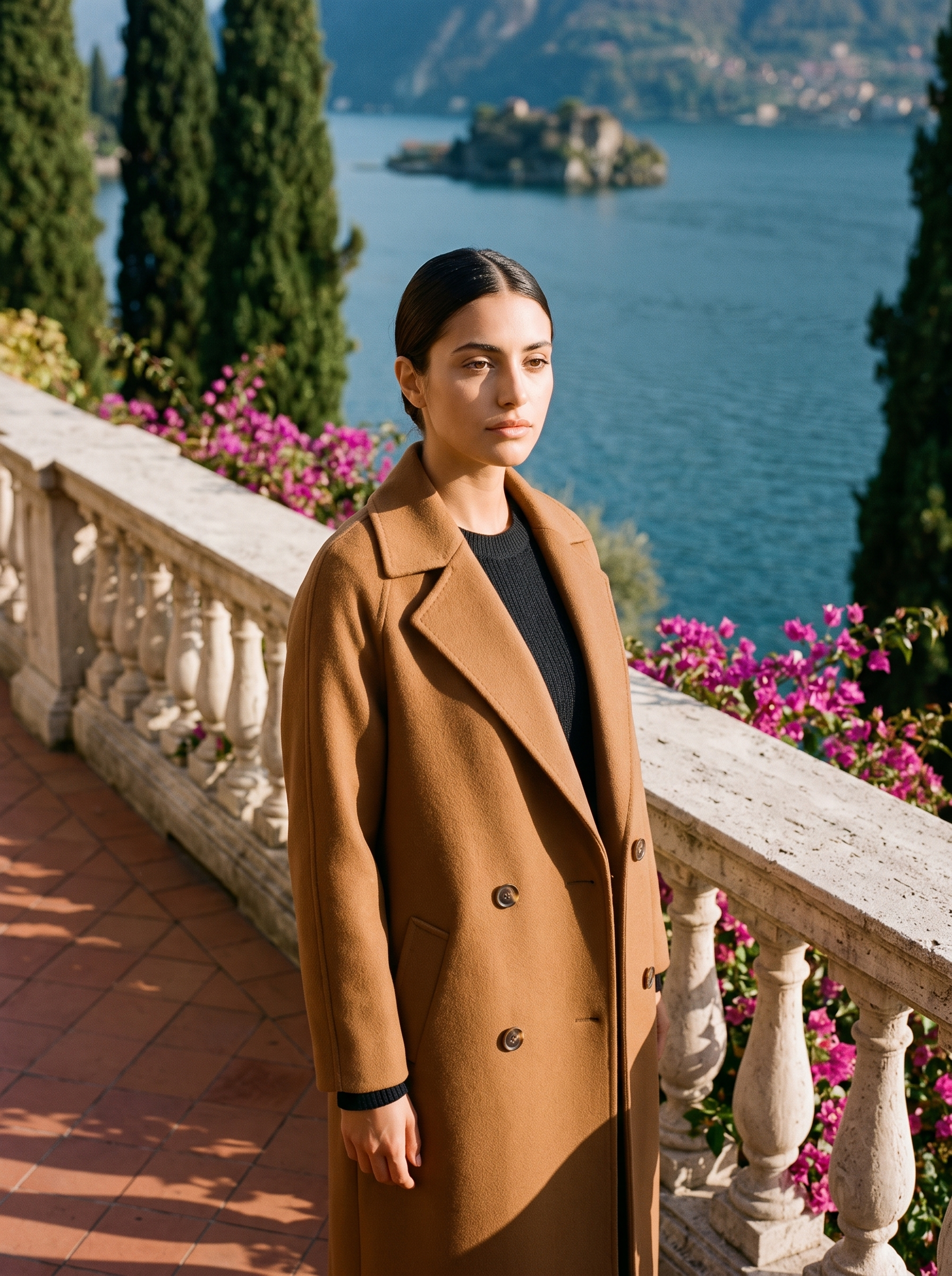Woman wearing camel brown double-breasted wool coat on a Lake Como terrace
