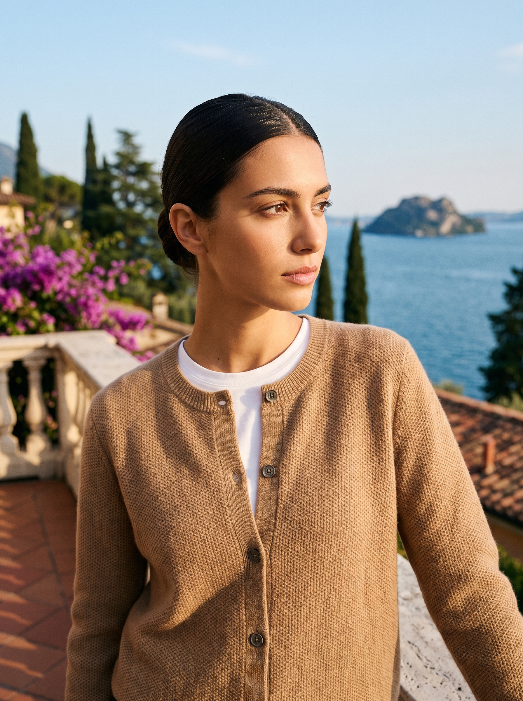Woman wearing a camel wool-blend cardigan on a terrace overlooking Lake Como, old money style — Aveloire
