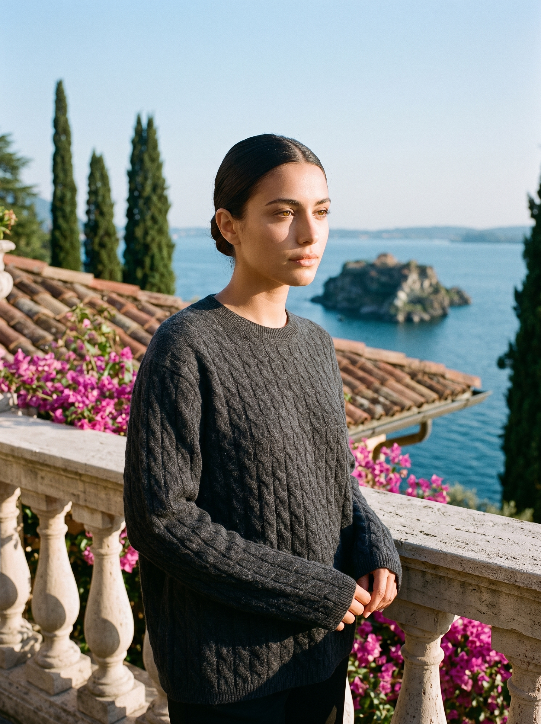 Woman wearing a dark grey cable-knit jumper on a terrace overlooking Lake Como — Aveloire