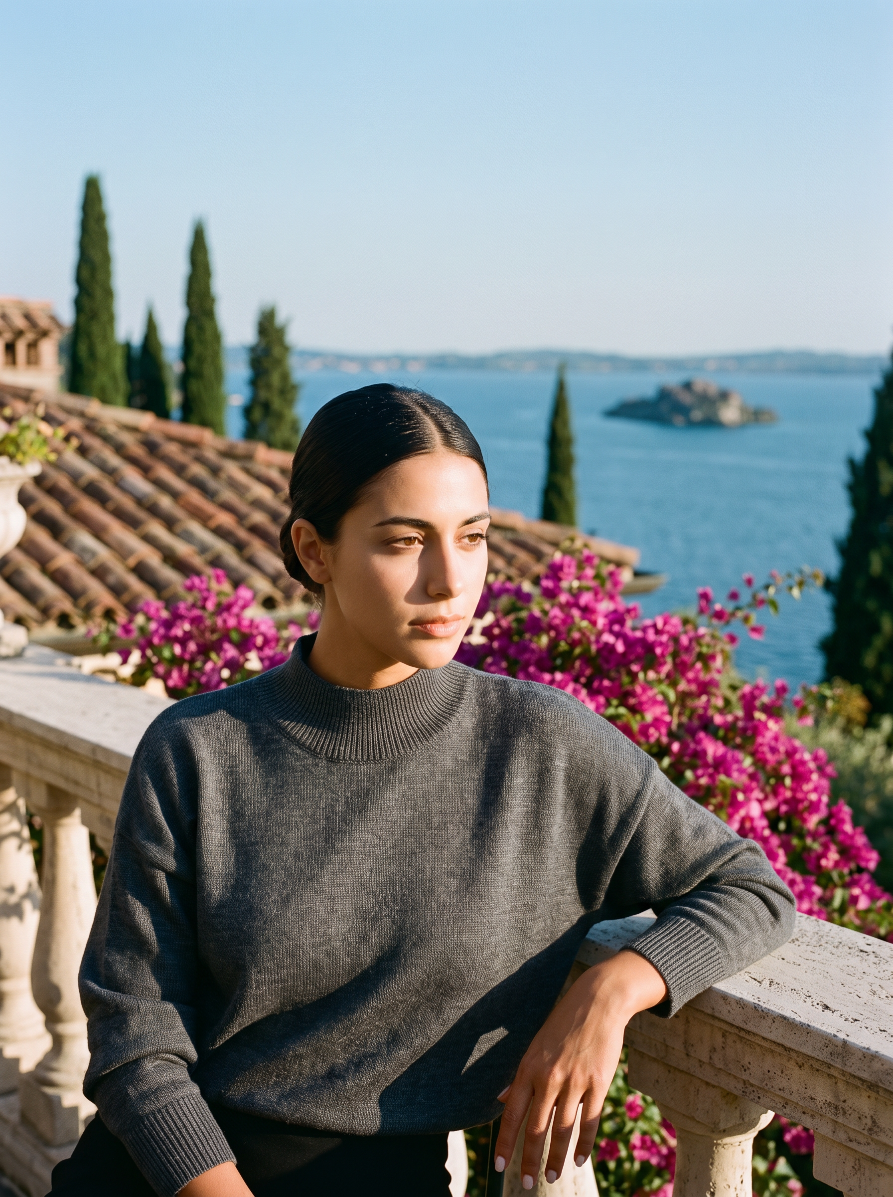 Woman wearing a dark grey mock-neck jumper on a terrace overlooking Lake Como — Aveloire