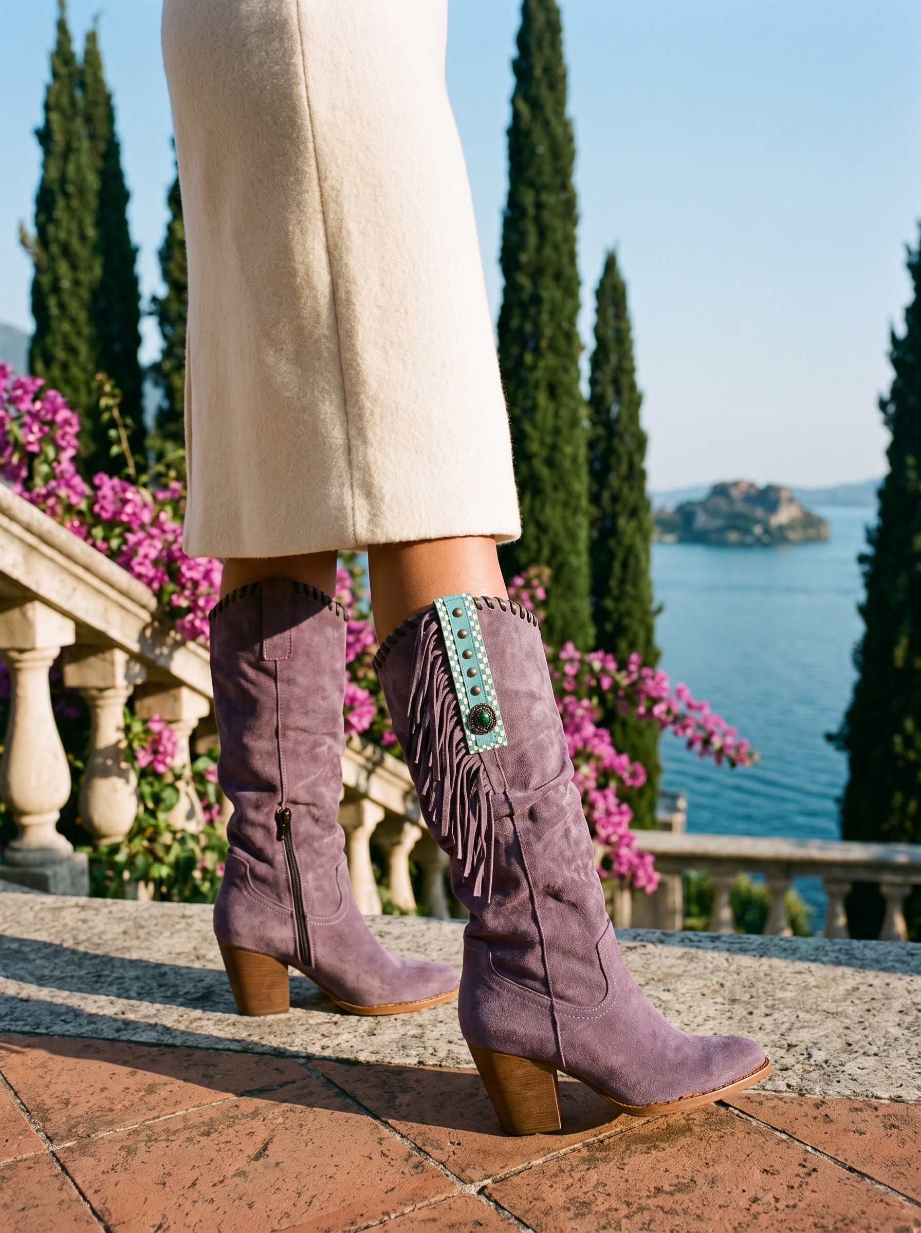 Woman wearing dusty purple fringed western knee high boots on a terrace overlooking Lake Como — Aveloire