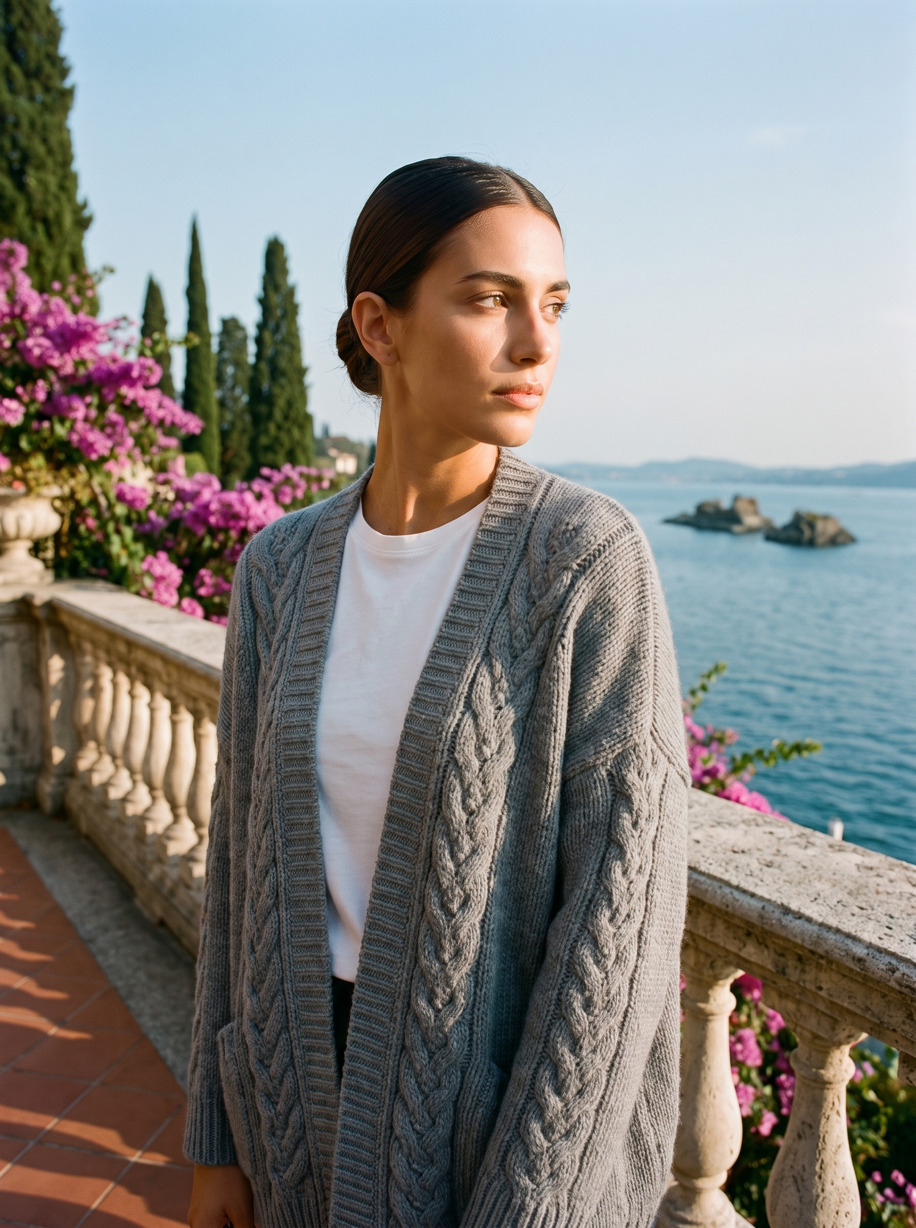 Woman wearing a gray open-front cardigan on a terrace overlooking Lake Como, old money style — Aveloire