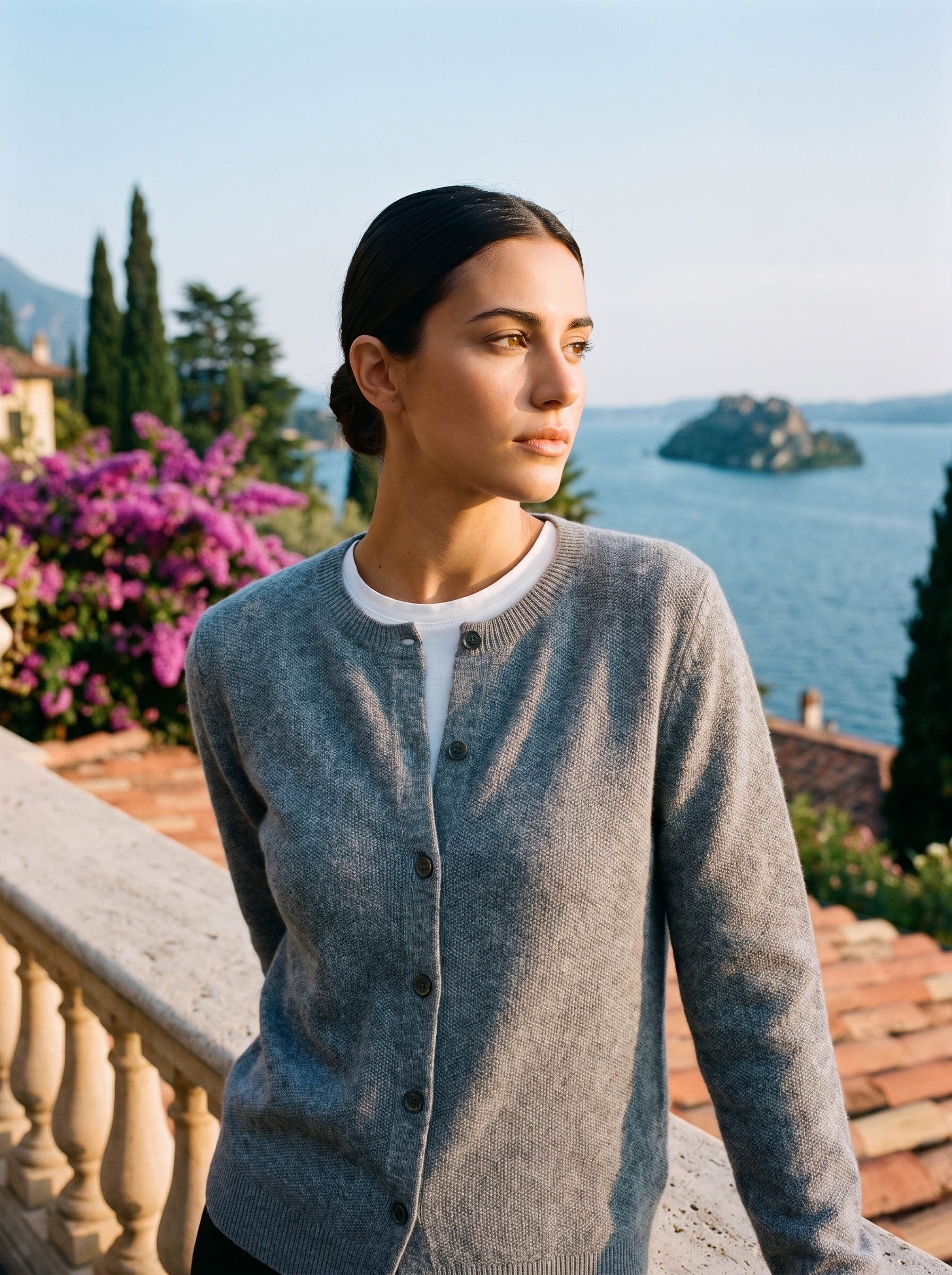 Woman wearing a gray wool-blend cardigan on a terrace overlooking Lake Como, old money style — Aveloire