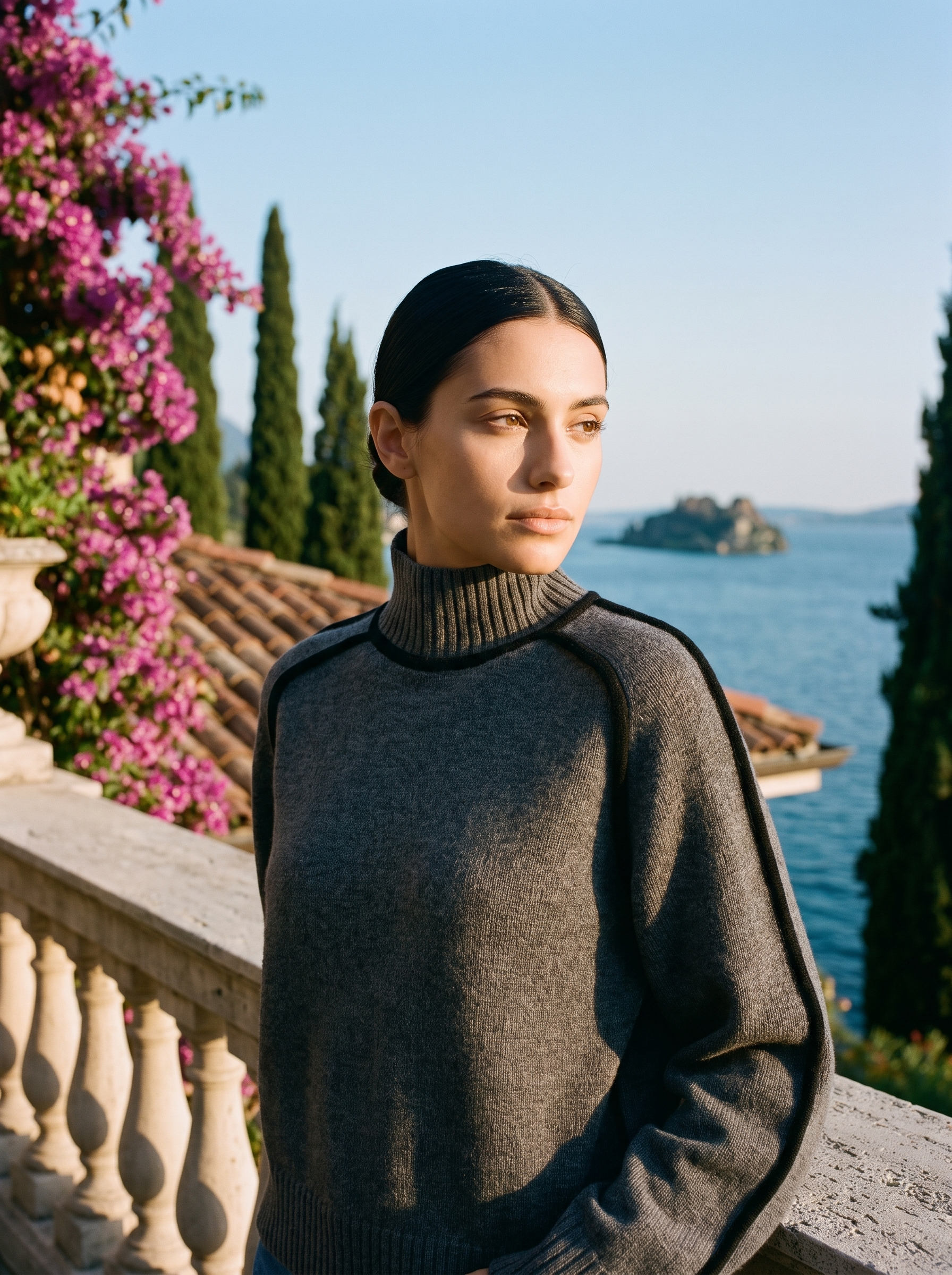 Woman wearing a grey contrast-trim turtleneck jumper on a terrace overlooking Lake Como — Aveloire