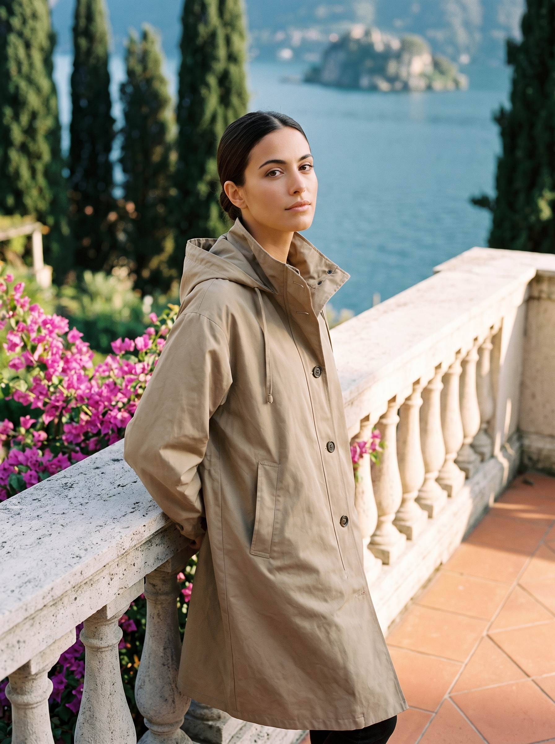 Woman wearing warm khaki-tan water-repellent hooded raincoat on a Lake Como terrace