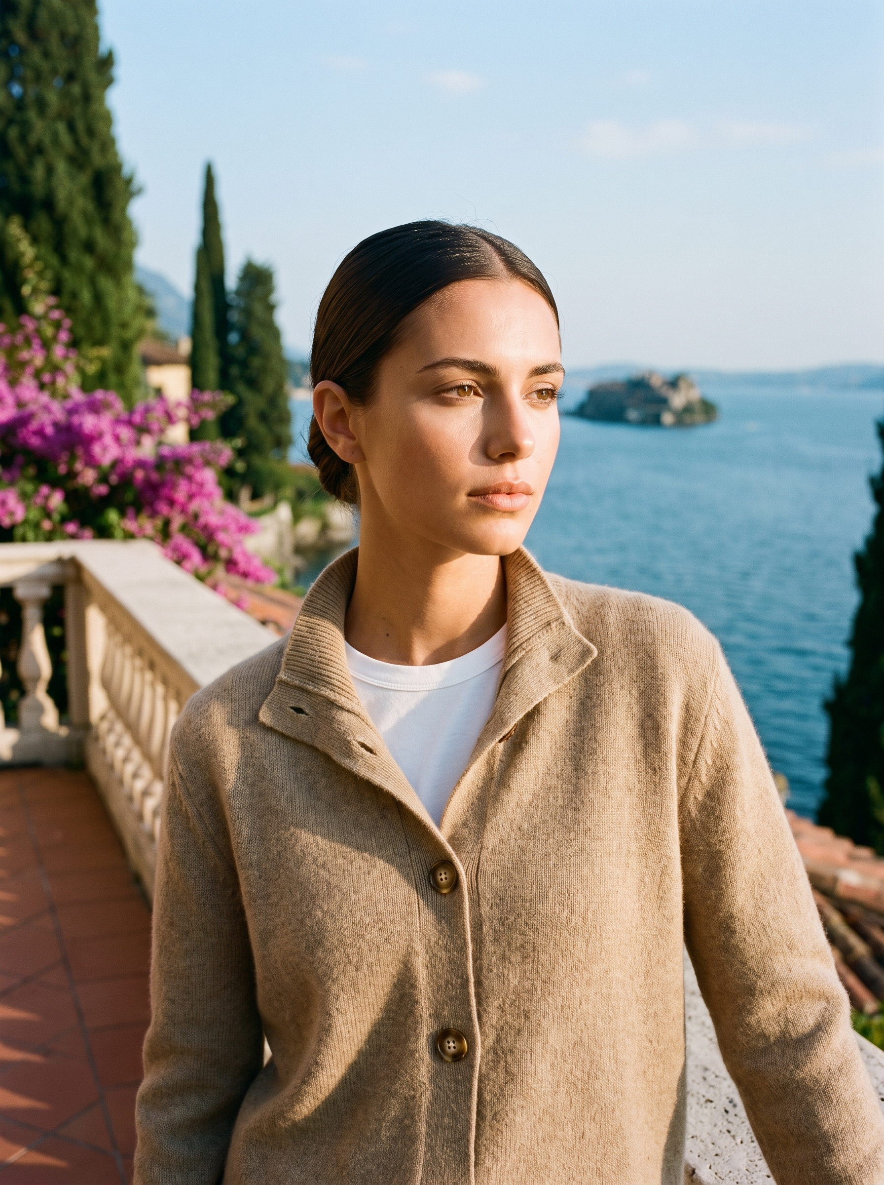 Woman wearing a khaki stand-collar cardigan on a terrace overlooking Lake Como, old money style — Aveloire