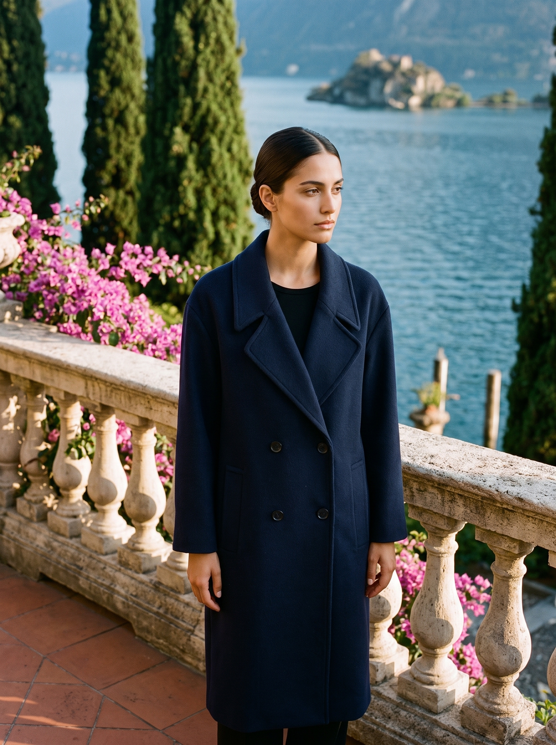 Woman wearing a navy double-breasted wool overcoat on a Lake Como terrace — Aveloire