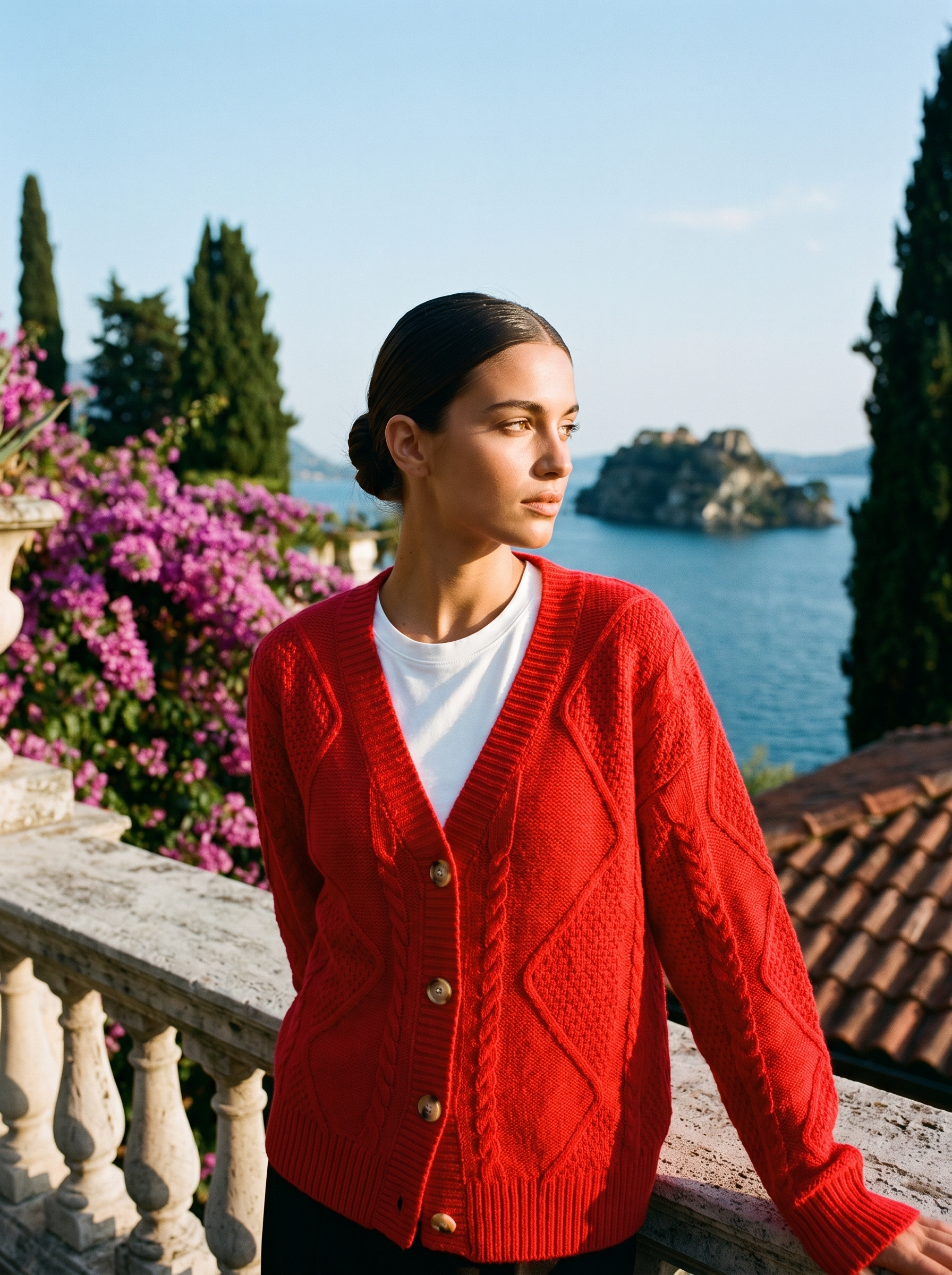 Woman wearing a red cable-knit cardigan on a terrace overlooking Lake Como, old money style — Aveloire